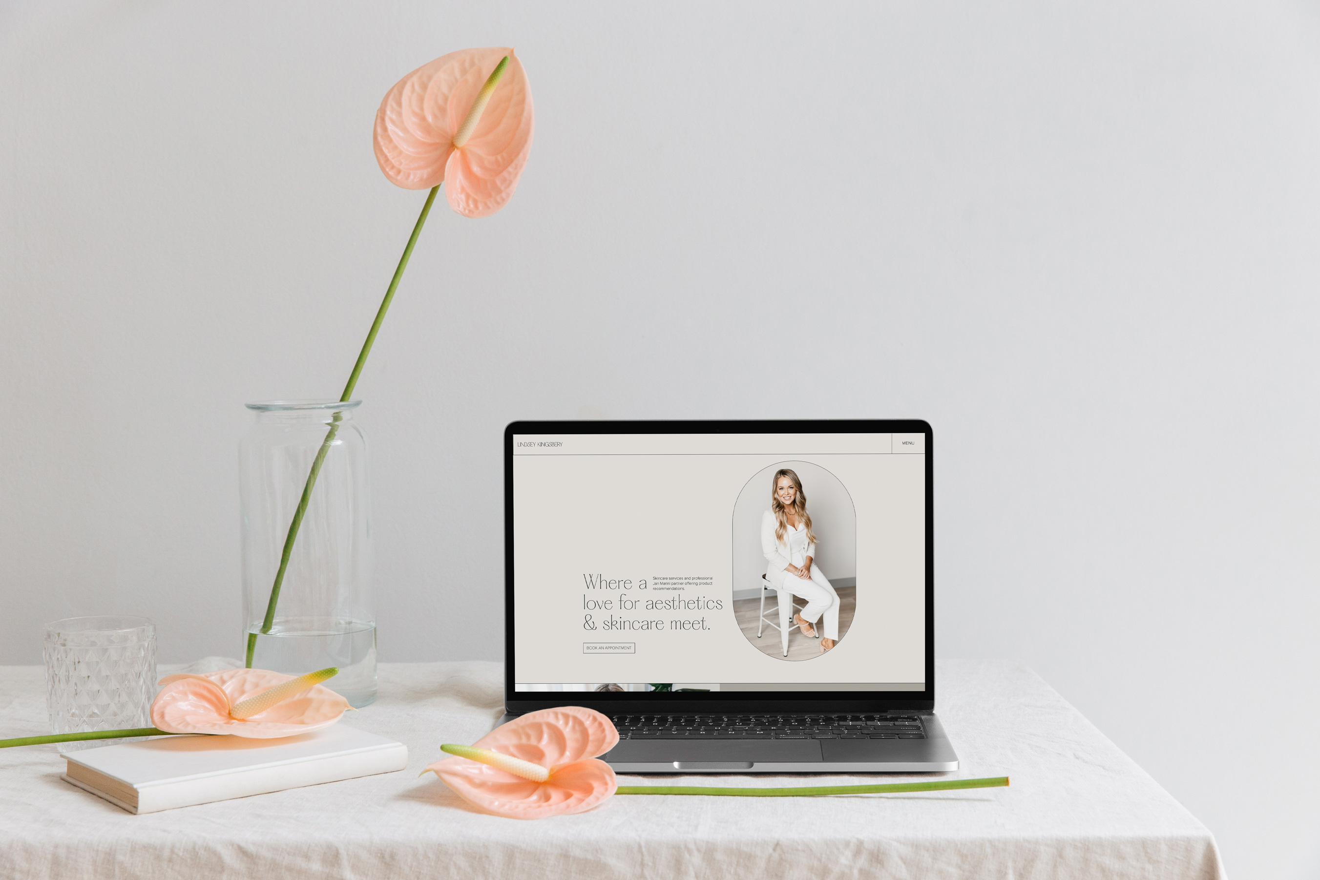 Website mockup on a table with flowers.