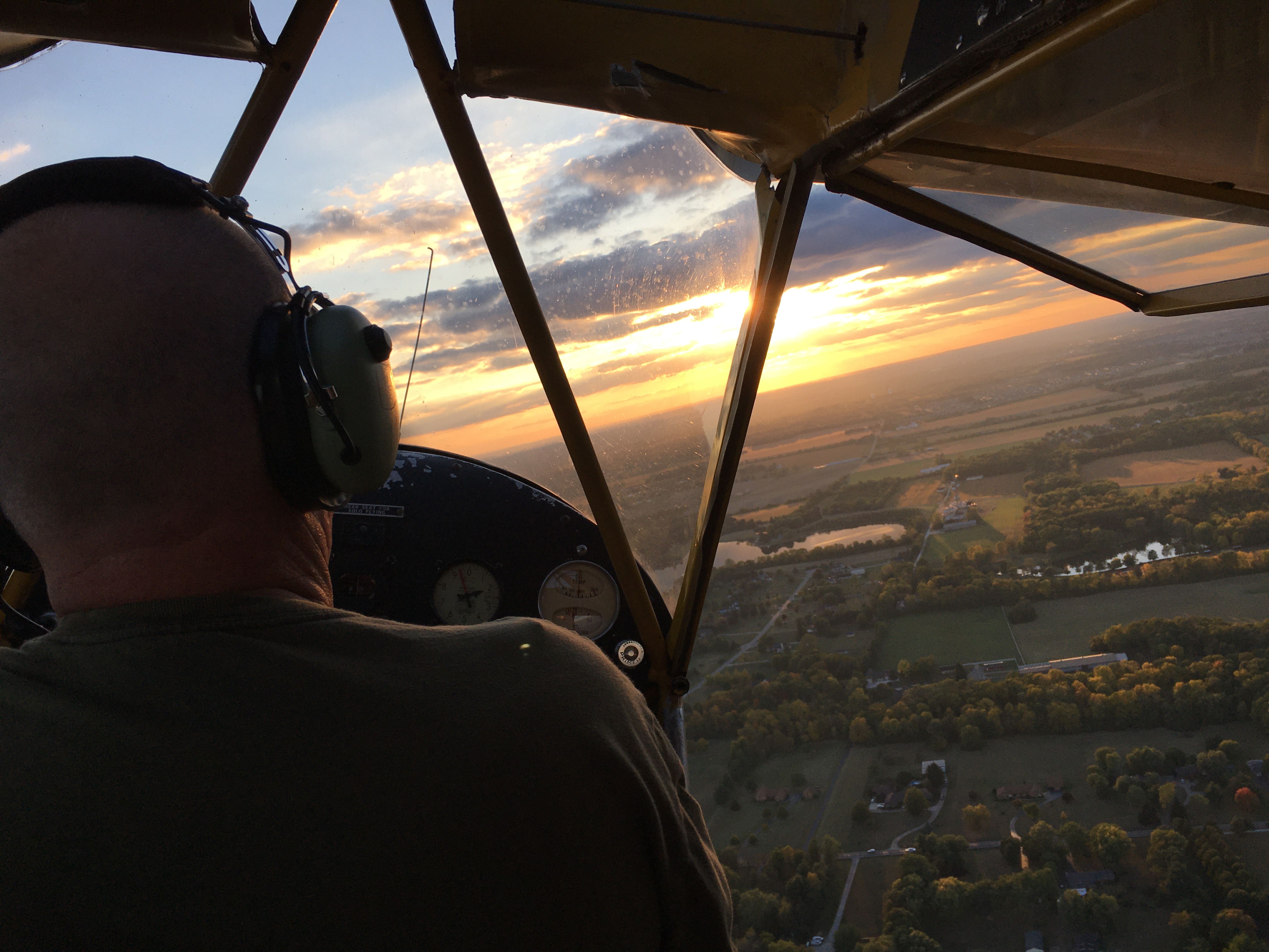 Michael Stewart flying a J3 Cub tailwheel aircraft at sunset, view from the cockpit over the Ohio countryside