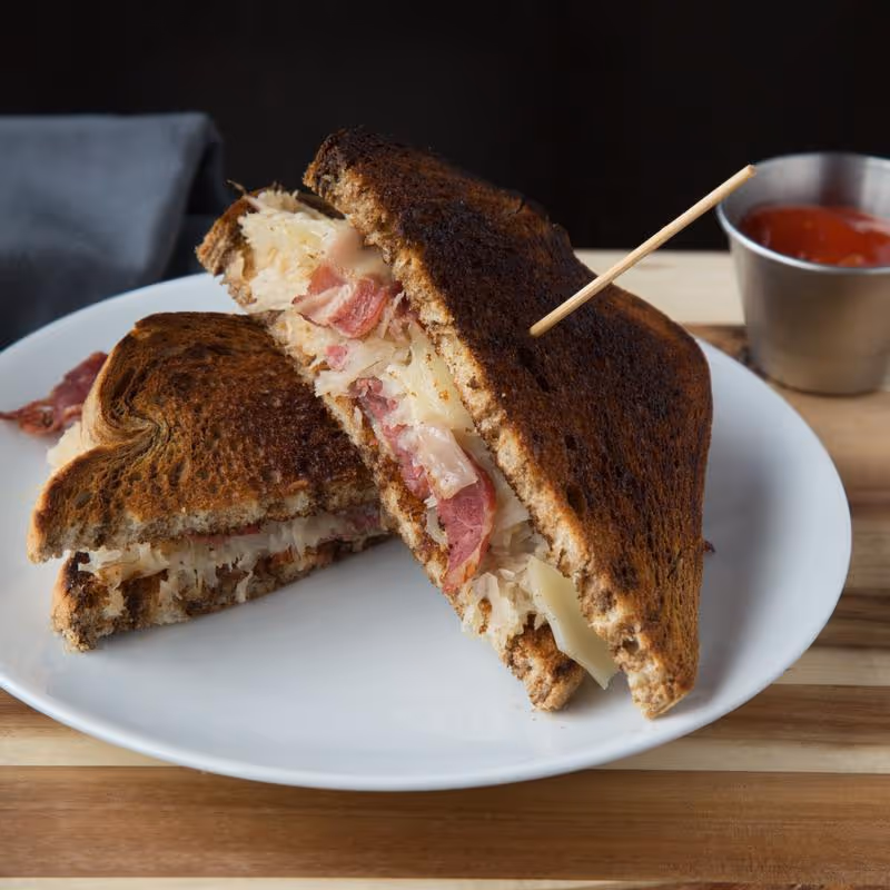 pastrami sandwich with cheese, cut in half