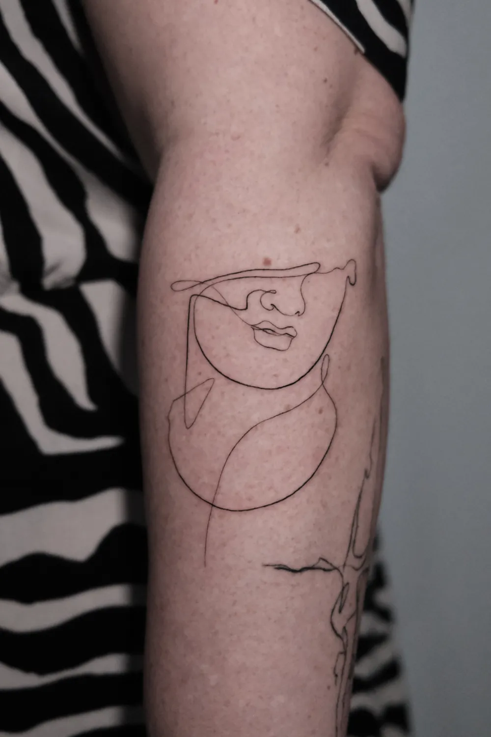 Fineline Lineart Gesicht Oneline Tattoo am Unterarm - Tattoo Artist Hamburg