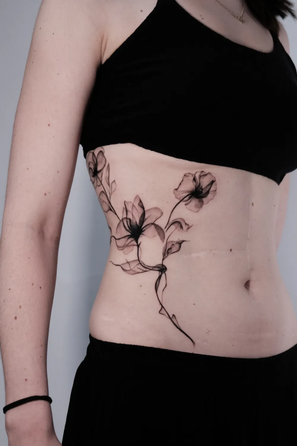 Fineline Blumen Tattoo am Bauch - Tattoo Artist Hamburg