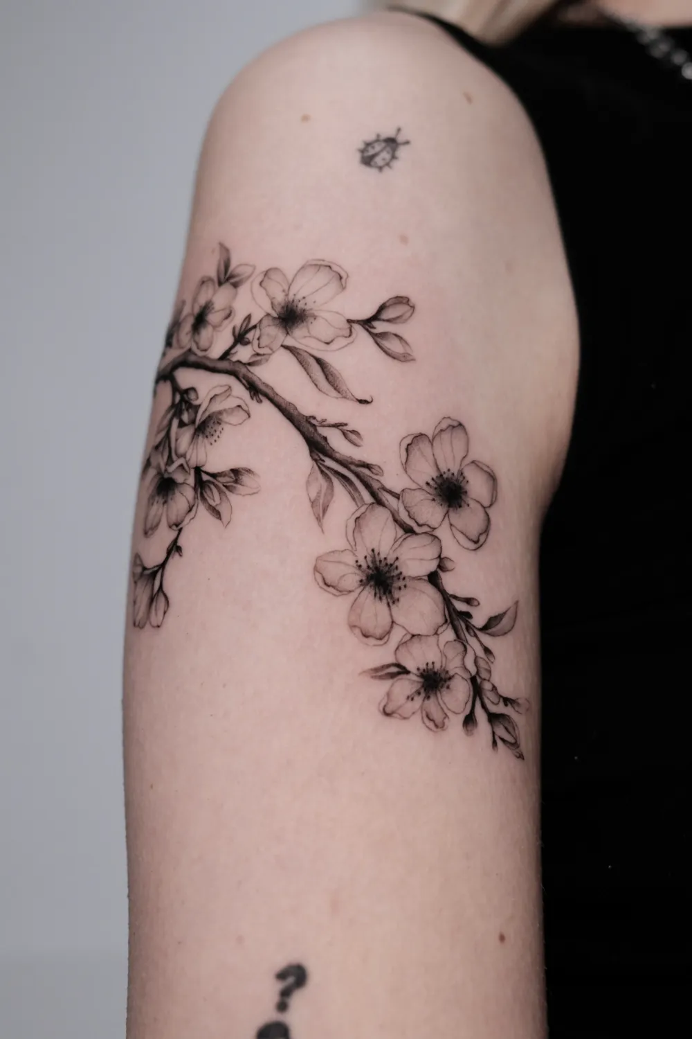 Fineline Blütenzweig Tattoo am Oberarm - Tattoo Artist Hamburg