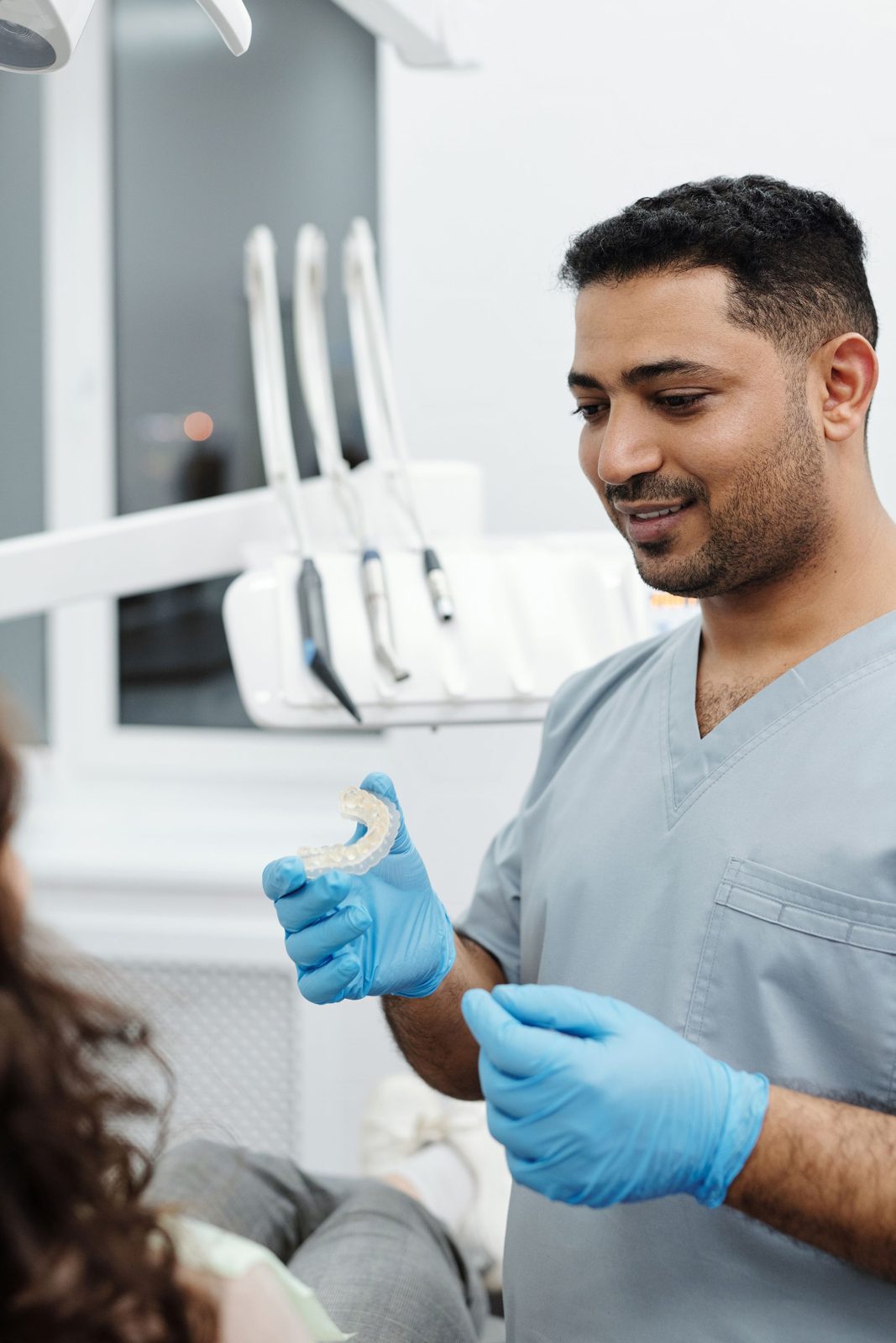 An orthodontist showing a patient a clear aligner during a visit