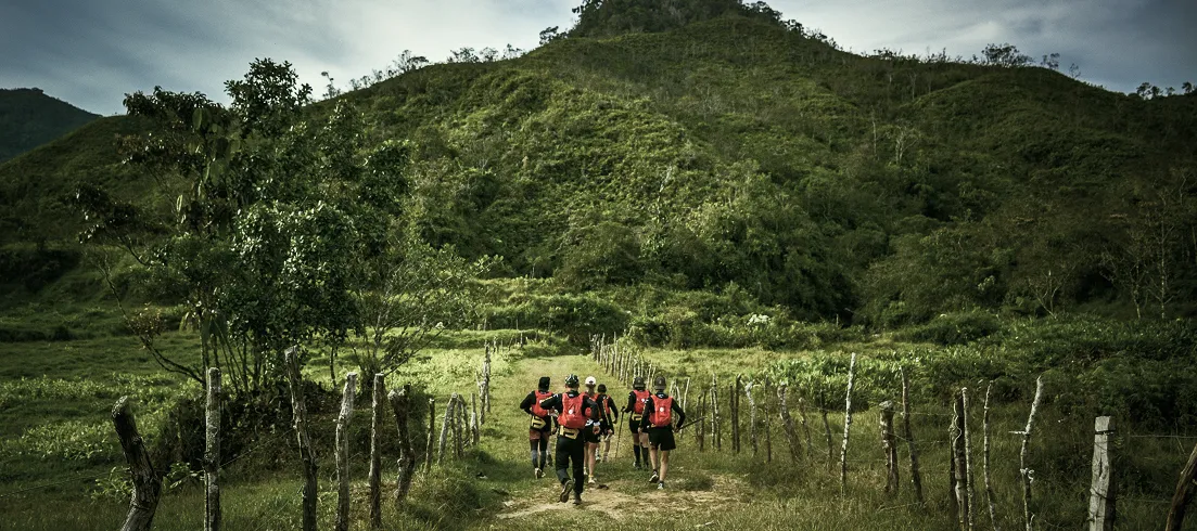 Expedition group heading up a grassy mountain trail in Antioquia, Colombia