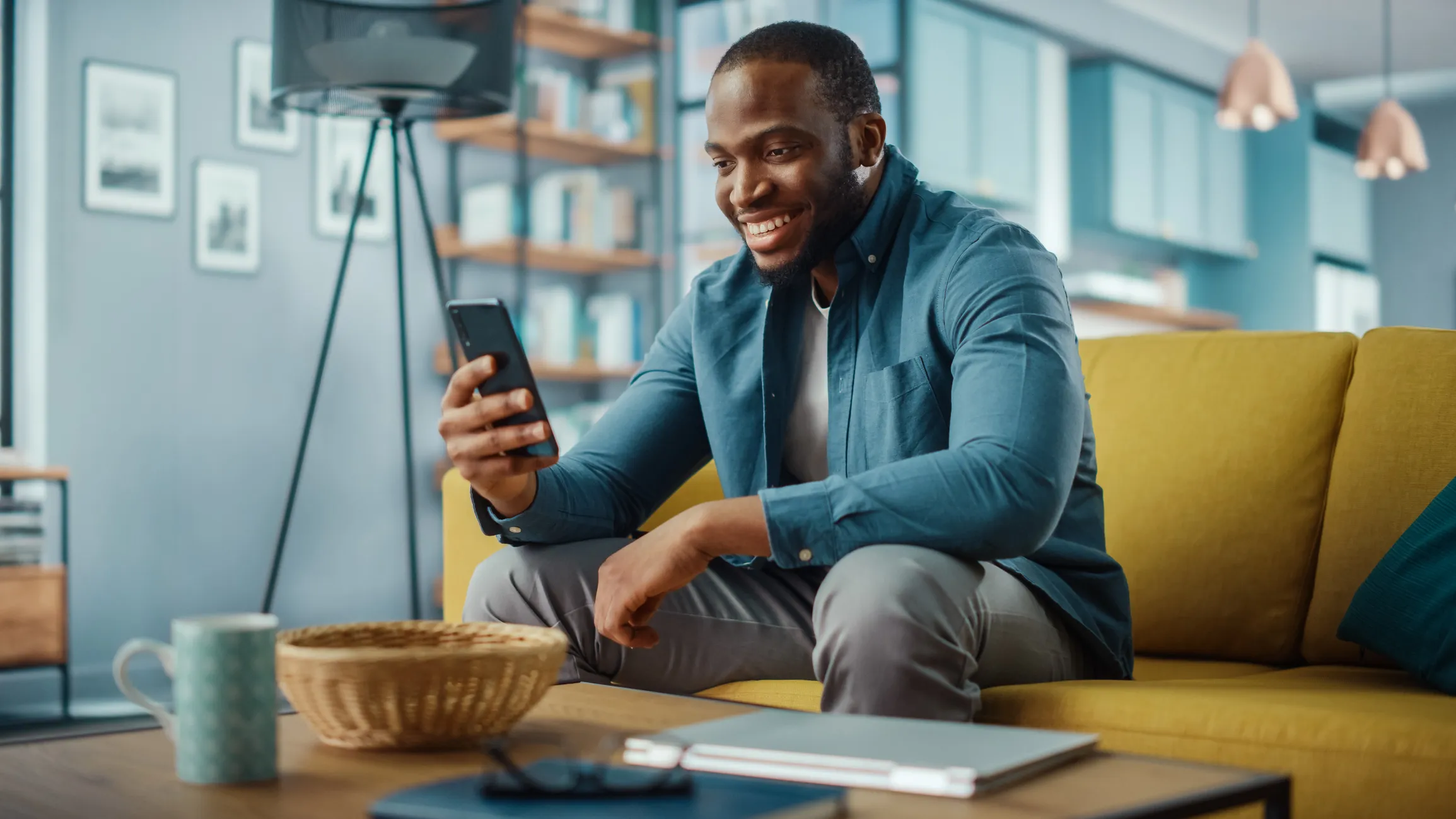 Excited Man Having a Video Call on Smartphone while Sitting on a Sofa in Living Room.
