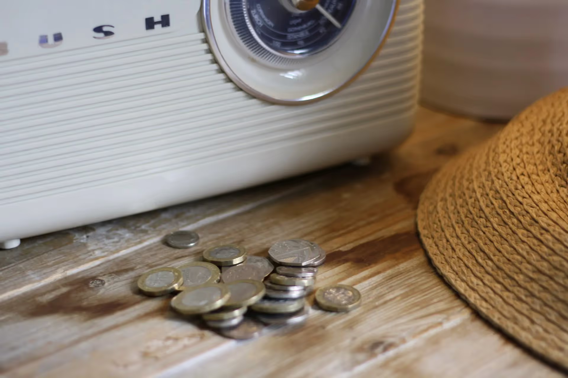 Pile of coins on a table in front of an art deco radio