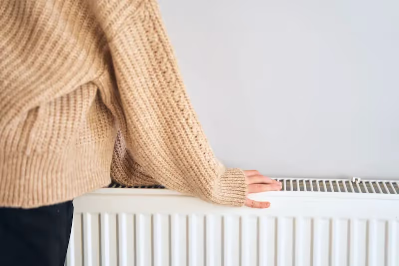 Lady resting against a double panelled radiator