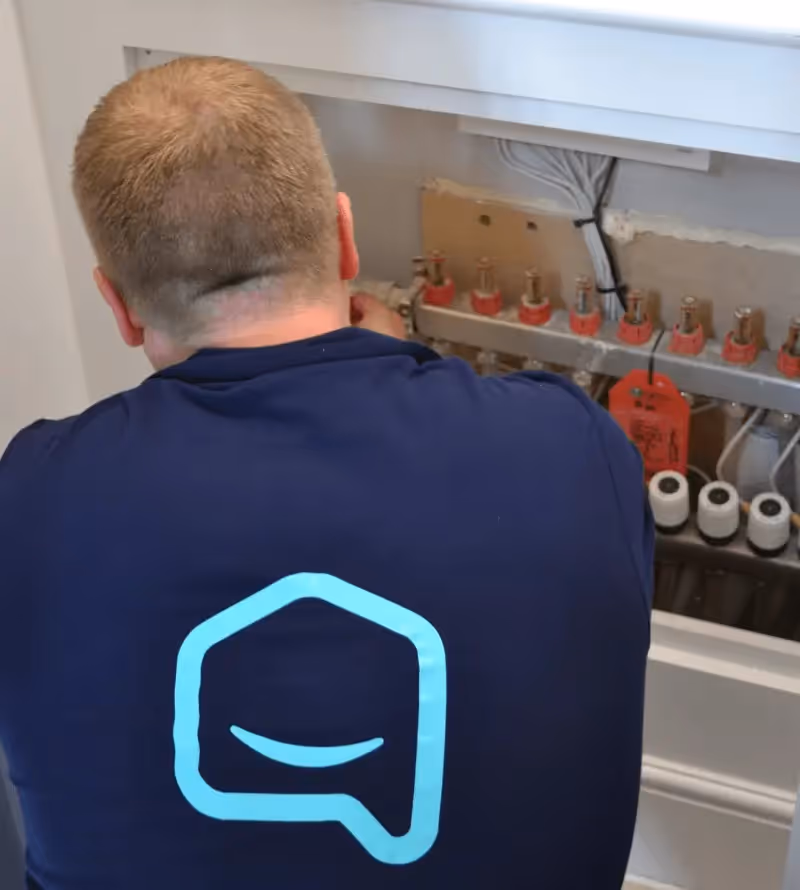 Dwellow installer inspecting an underfloor heating manifold