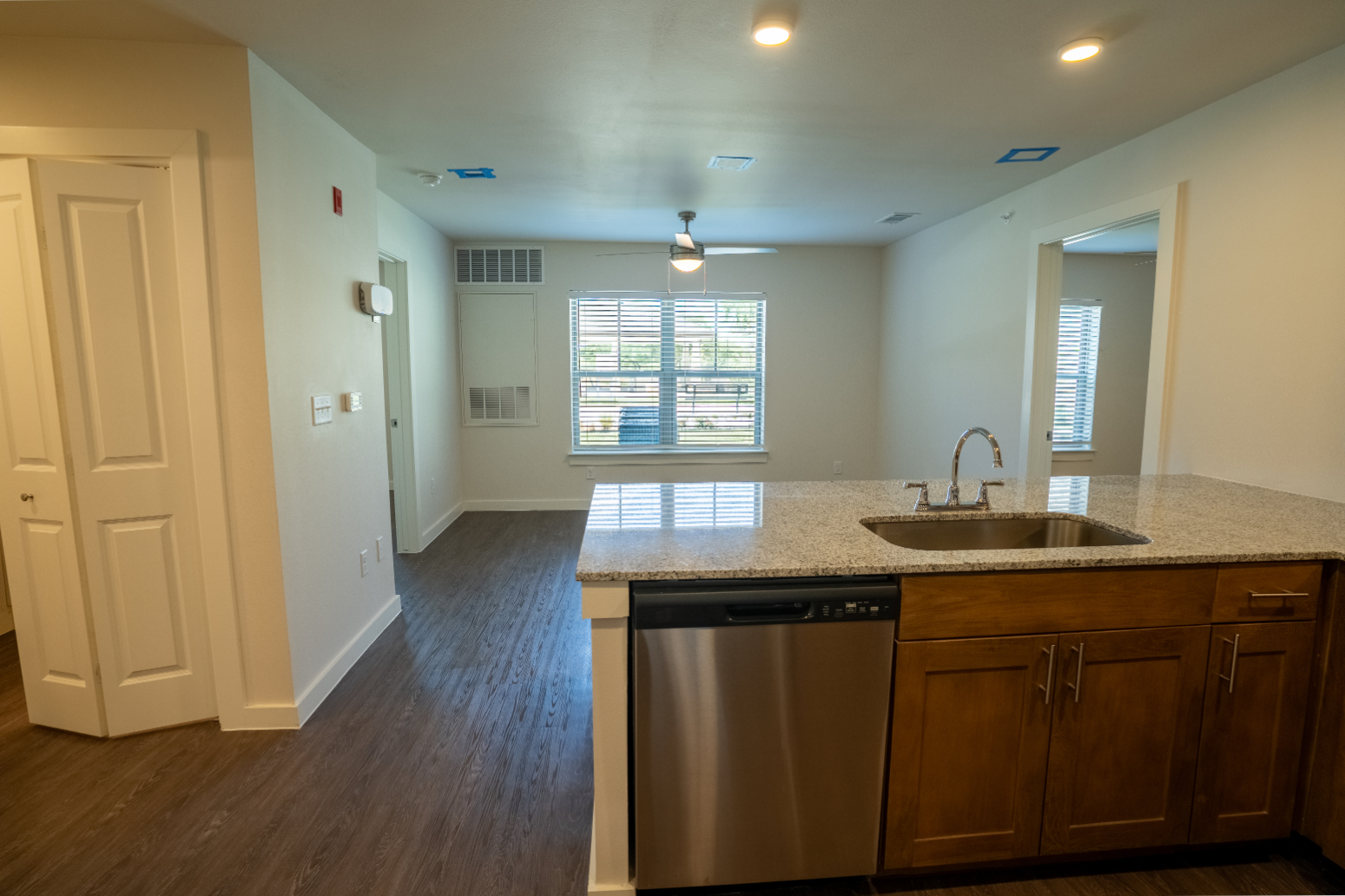 View of living area with large windows from kitchen