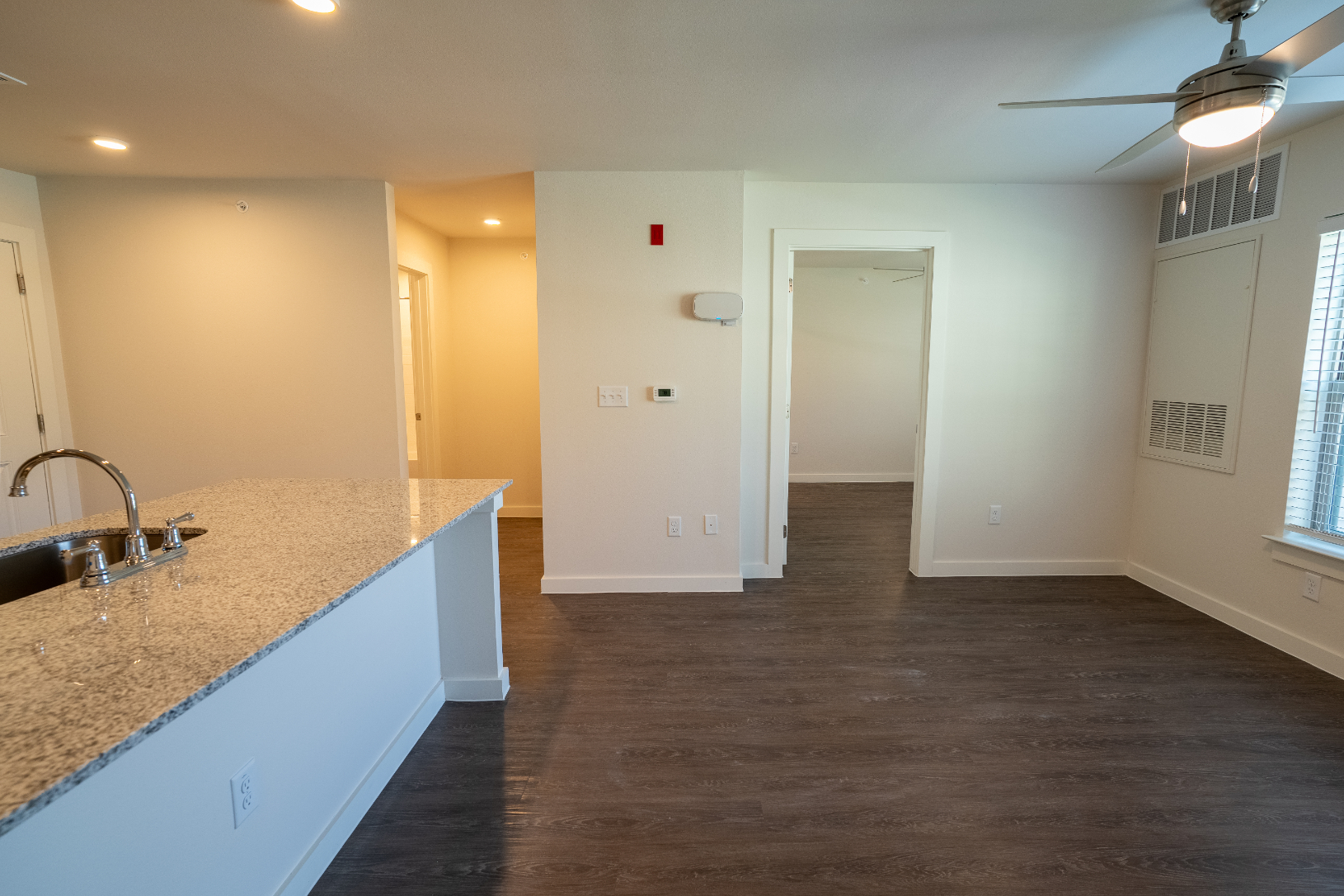 View of living area with large windows and kitchen breakfast bar with sink
