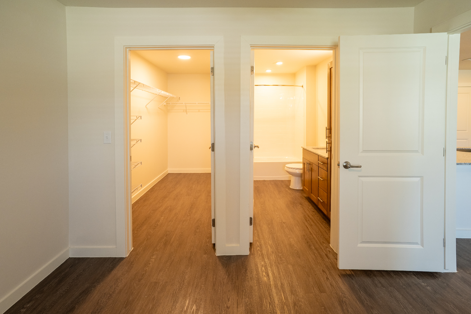 Unfurnished bed with large closet and view of bathroom 