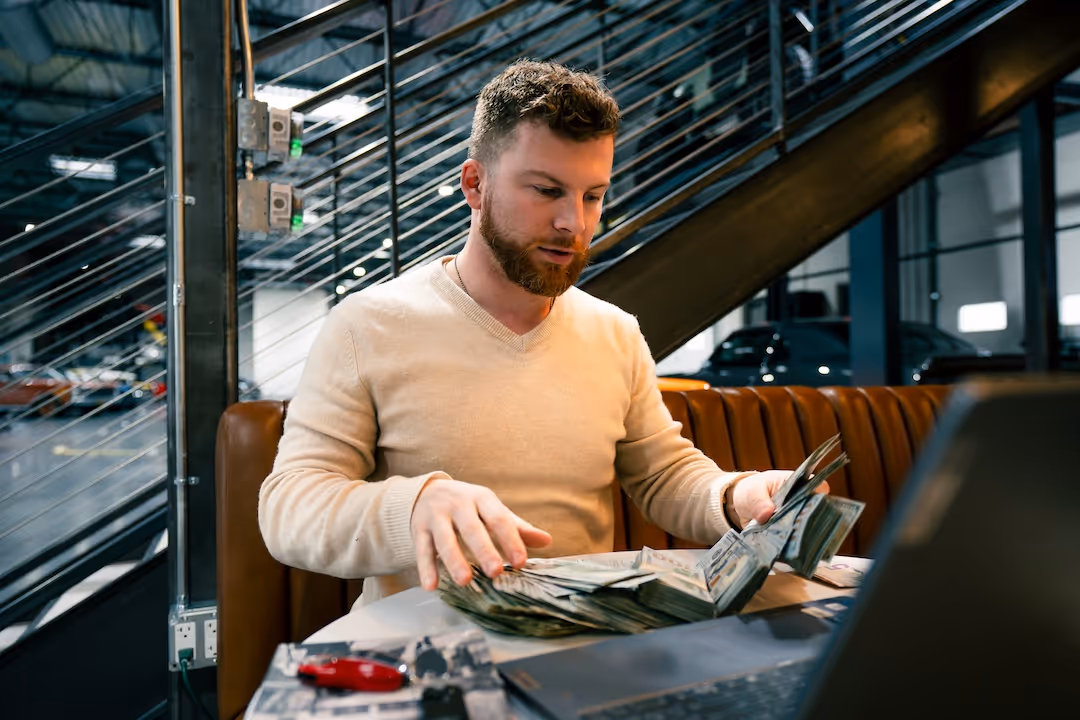 Ben Oberg sitting at table counting cash