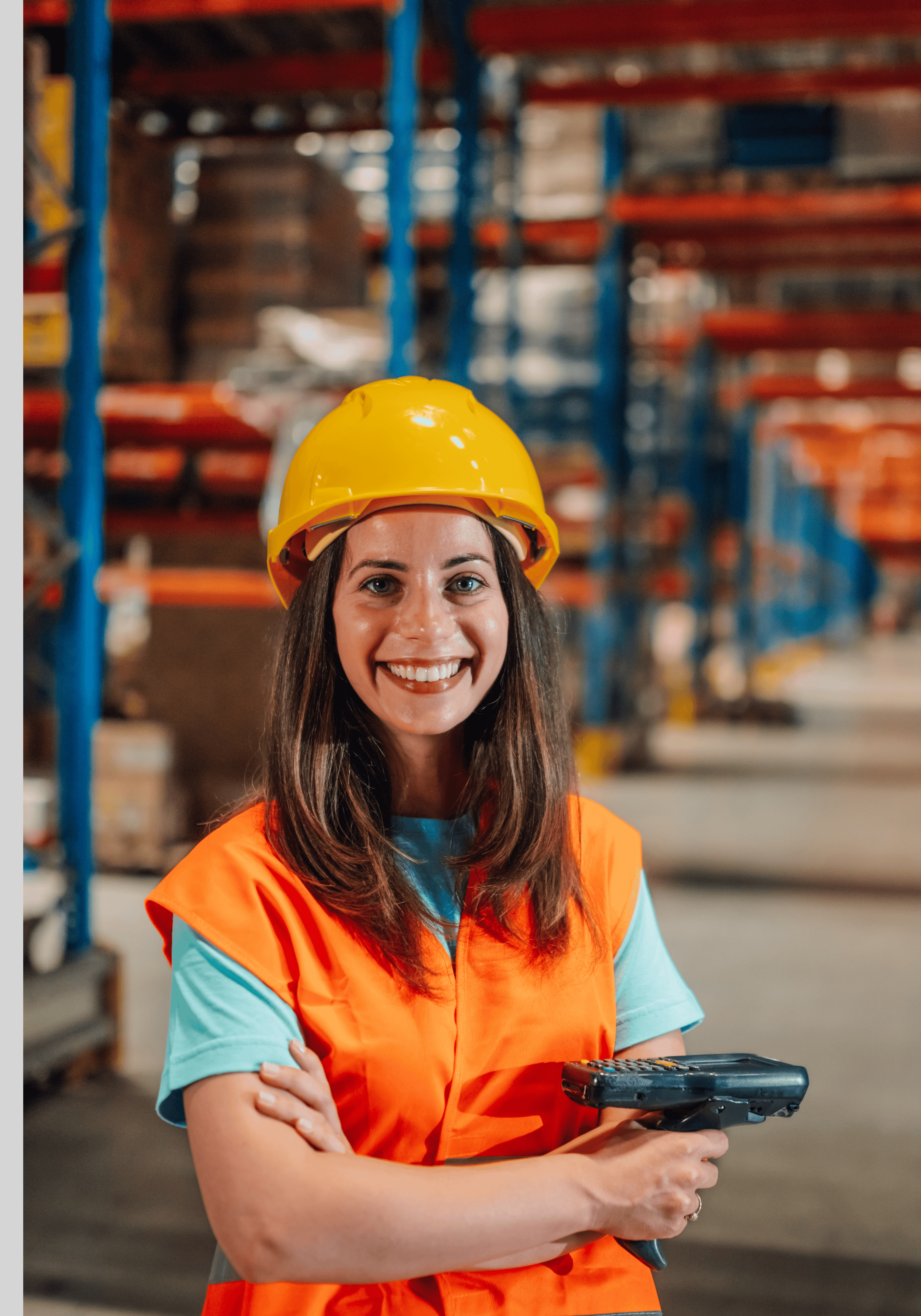 Professional young woman with dark hair in a bun, wearing a light blue shirt and dark blazer, smiling against a plain background.