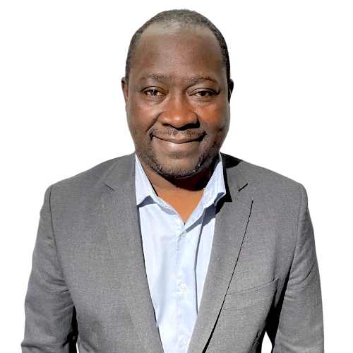 Homme souriant portant un costume gris et une chemise bleue claire.