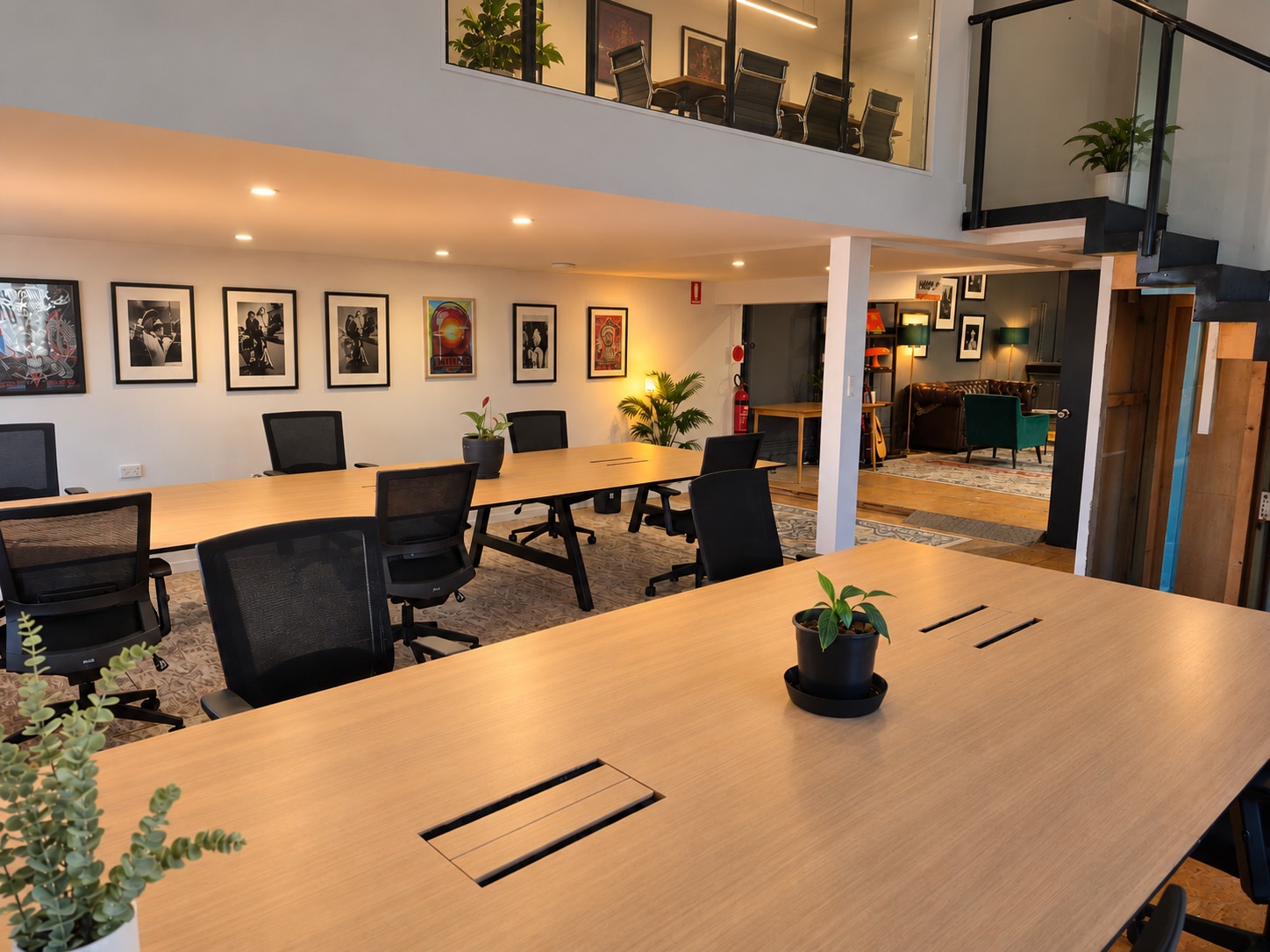 Dedicated desks at Jungle CoWork, with the lounge and upstairs boardroom in view