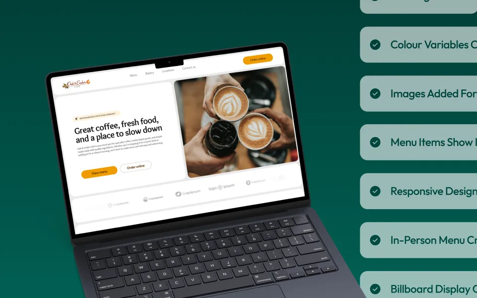 A laptop with a demo site on the screen. Cards showing items that have been completed are checked off in the background.