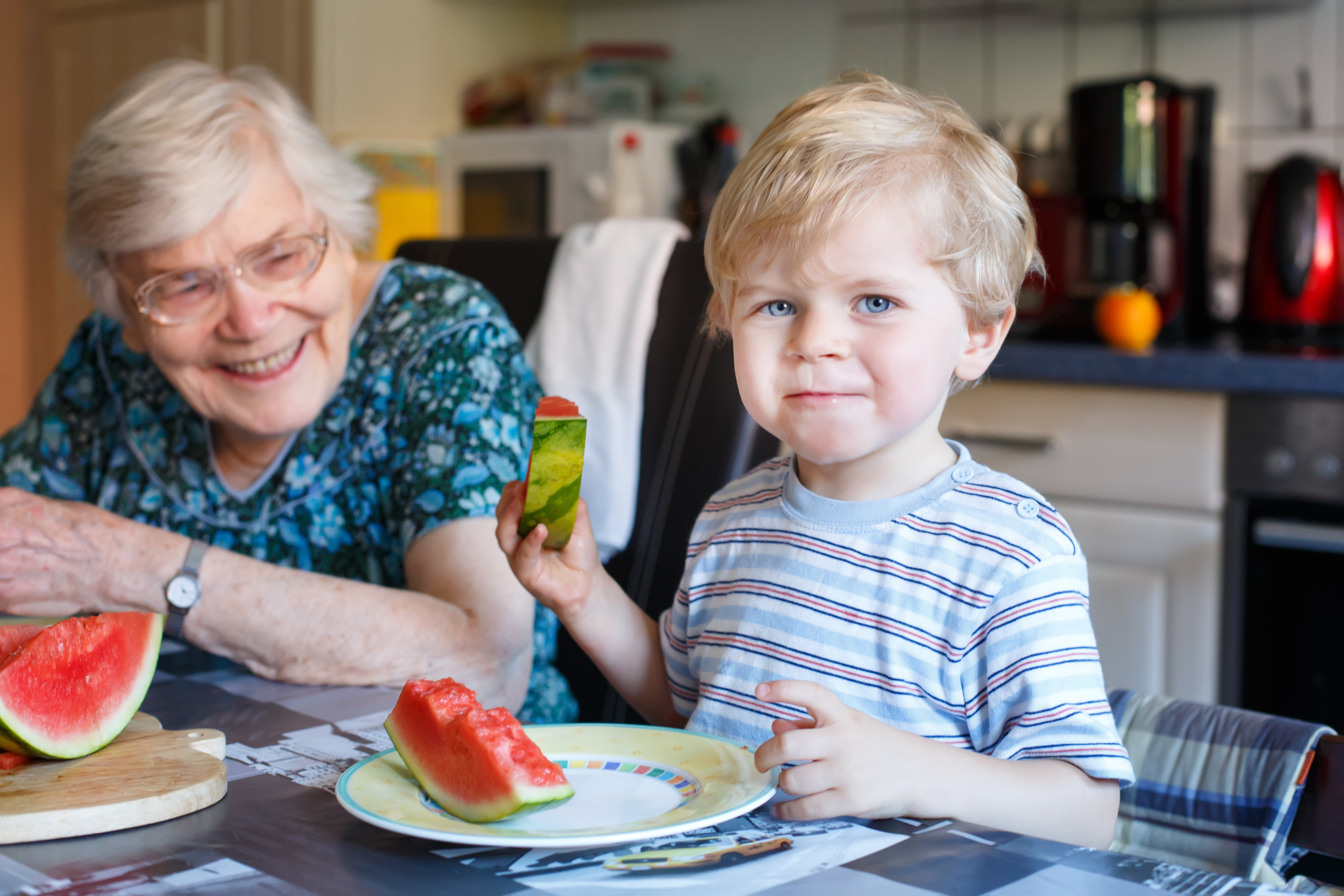 Group of smiling diverse people, including a man in a wheelchair with a child on his lap, giving thumbs up in front of a circle graphic stating '11/11/25 The day we hit our first $10K' and the website miahfamilies.org.