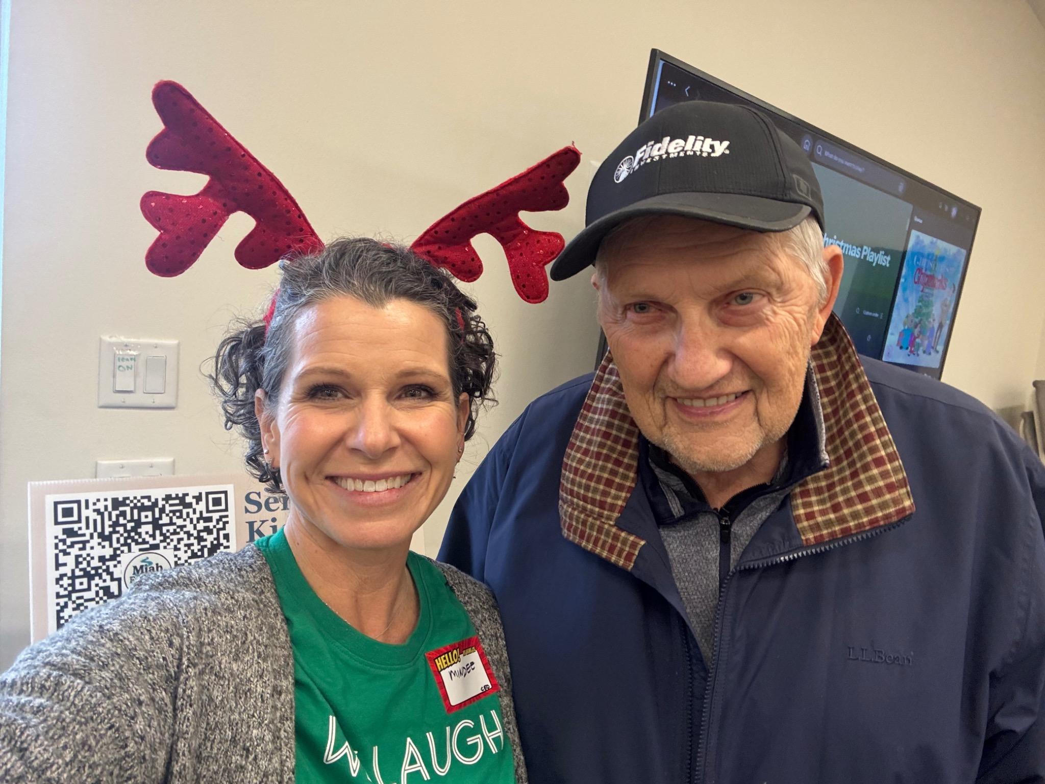 Smiling child with hands covered in vibrant multicolored paint held up toward the camera.