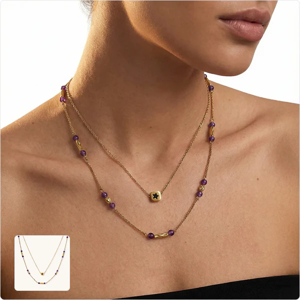 Close-up of a woman wearing layered gold necklaces with purple beads and a small gold pendant featuring a black star.