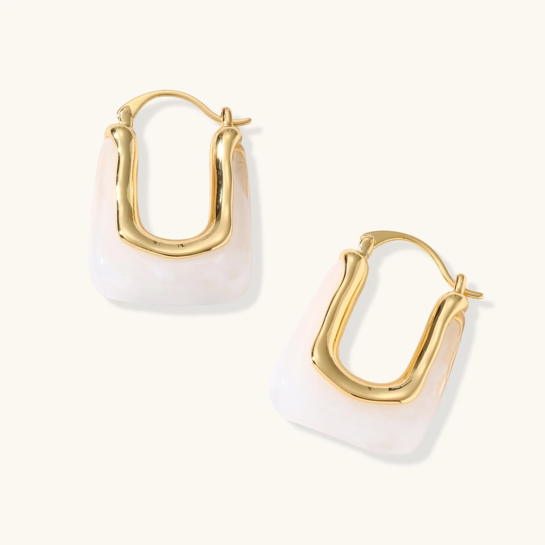 Gold-plated rectangular hoop earrings with a white enamel inlay.