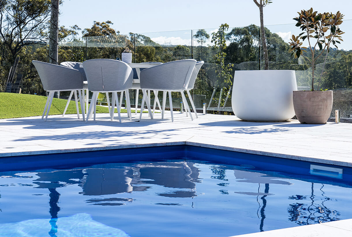 Sunlight rippling on deep blue backyard composite pool