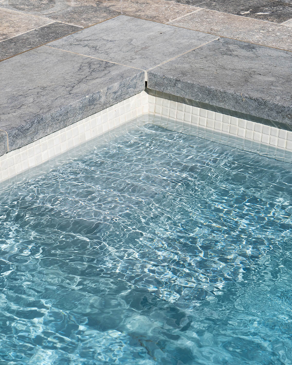 Close-up of pool water surface with light reflections and ripple detail