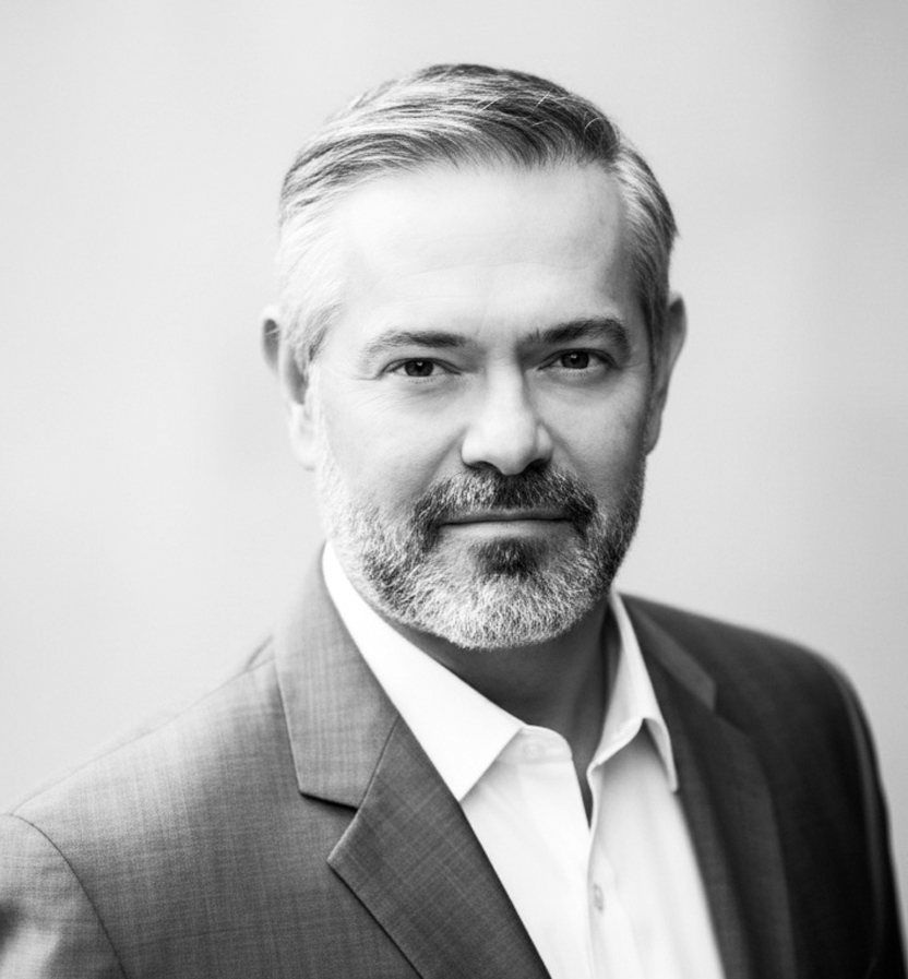 Black and white portrait of Mark Saunders wearing a suit jacket and white shirt.
