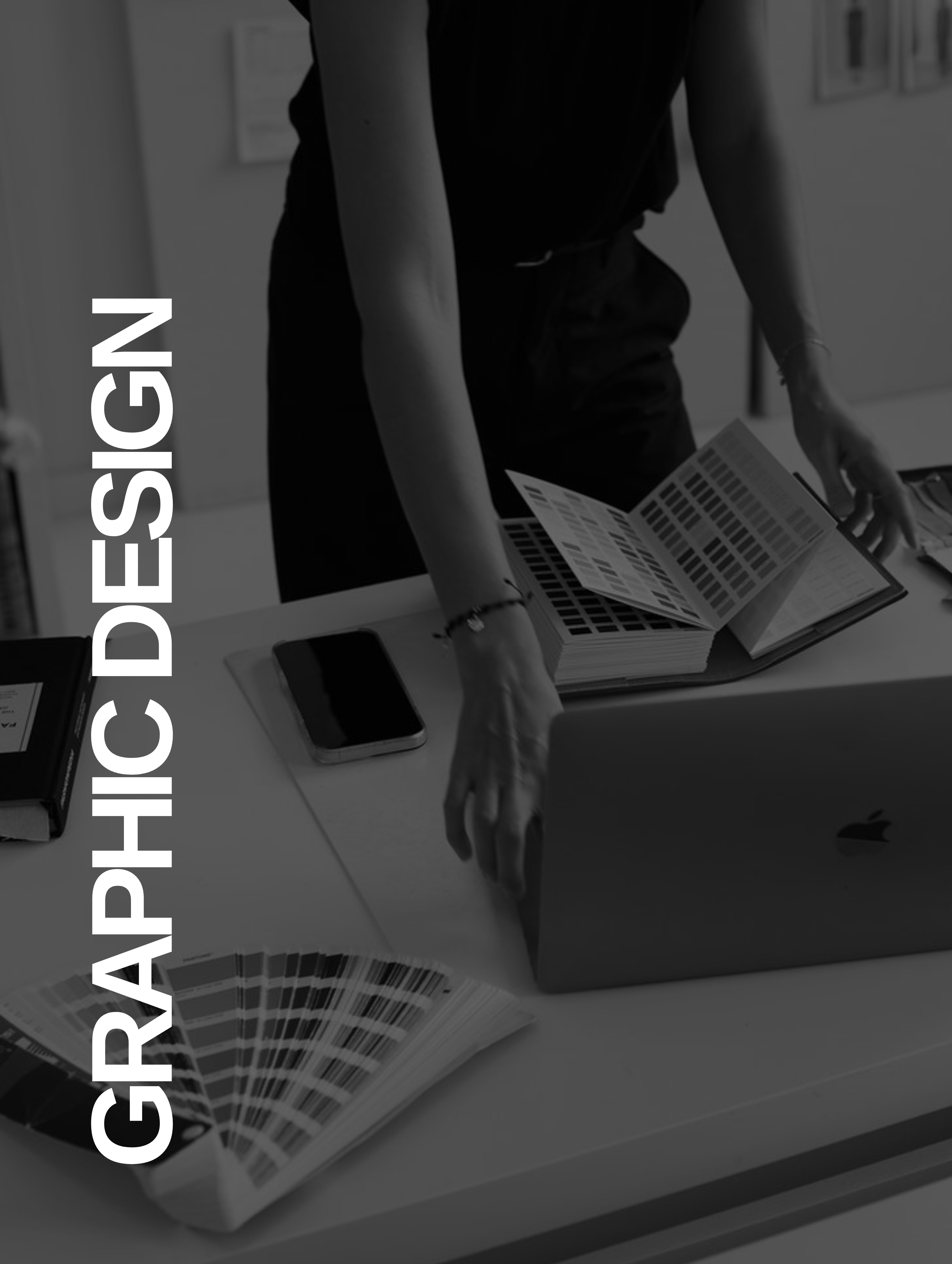 Person arranging color swatches on a desk with a laptop and phone, text graphic design on side.