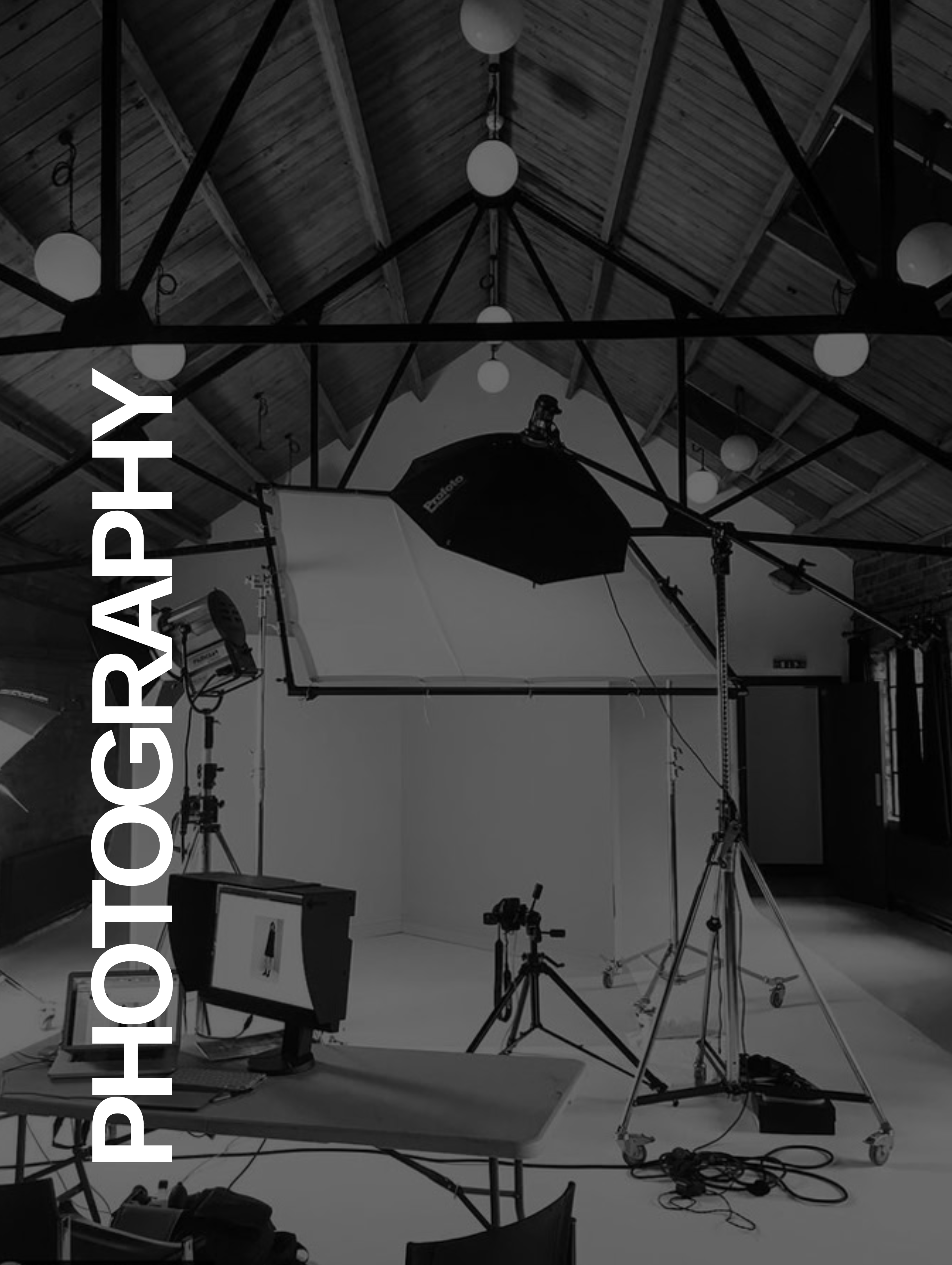 Professional photography studio setup with lighting equipment, cameras, and a white backdrop.