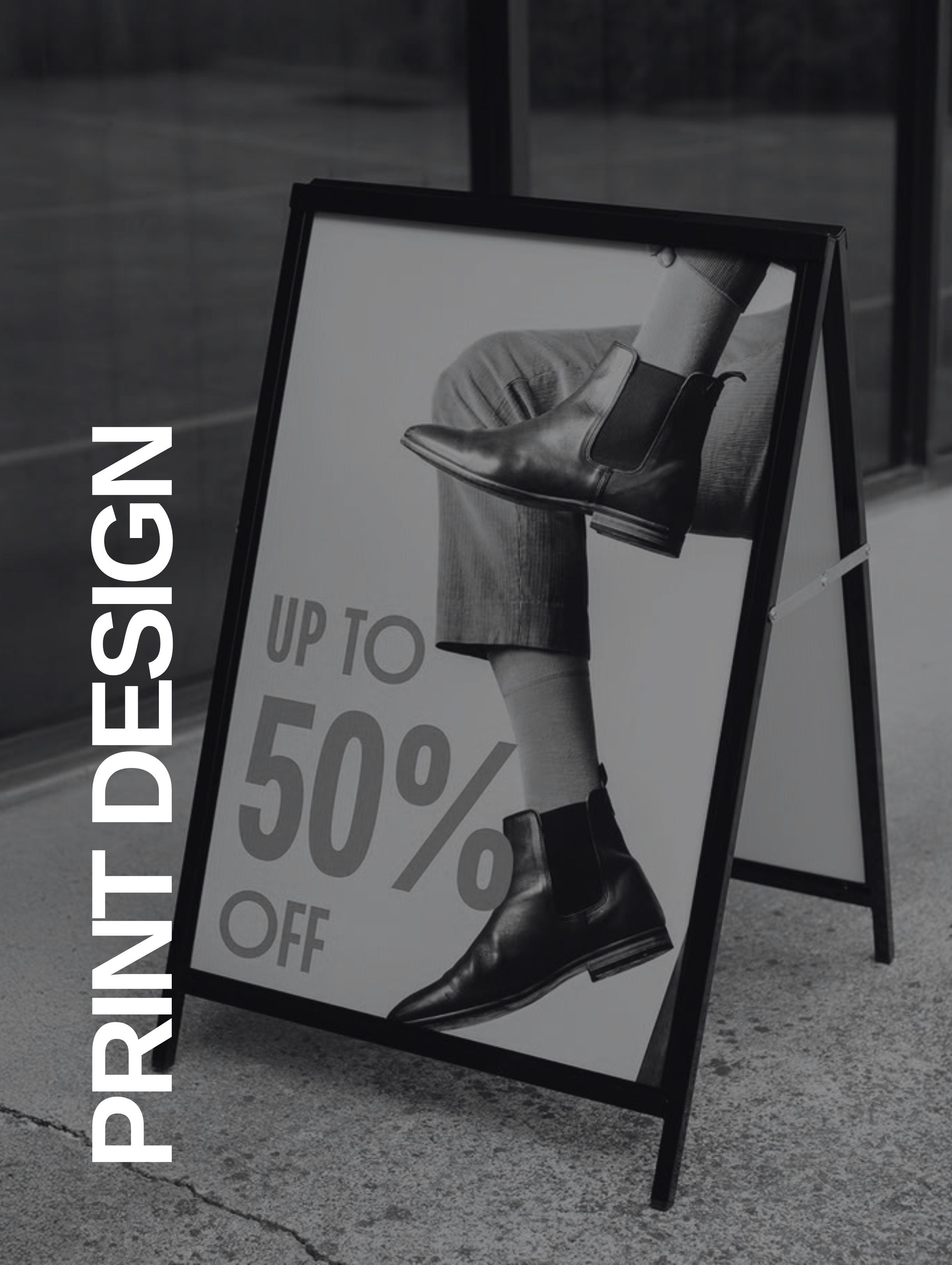 Sidewalk sign showing black leather boots worn with rolled pants and text offering up to 50% off.