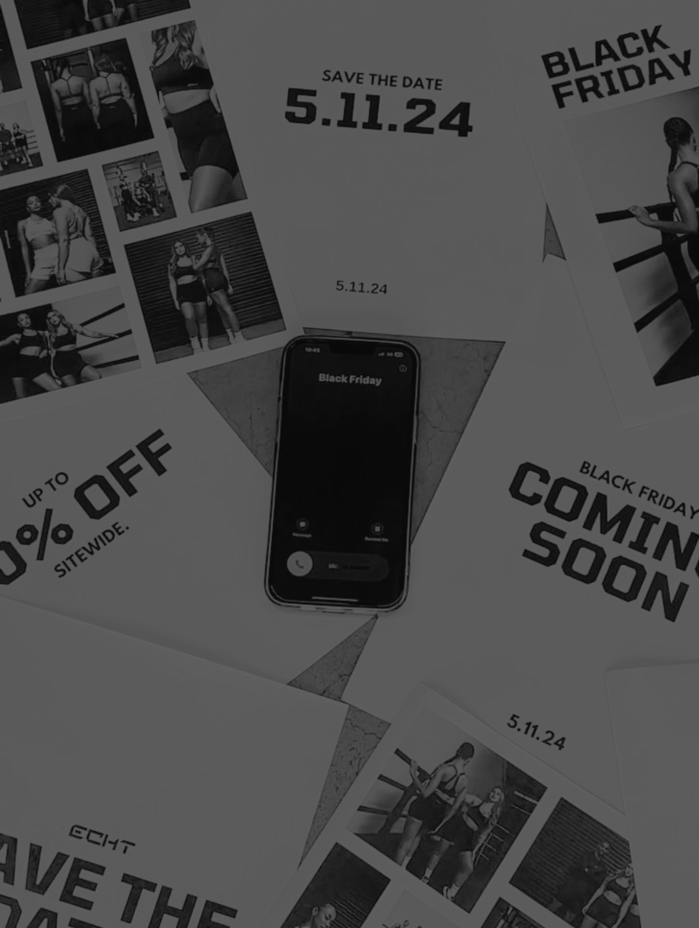 Flat lay of Black Friday sale flyers and a smartphone on a surface showcasing discount offers and a Save the Date notice.