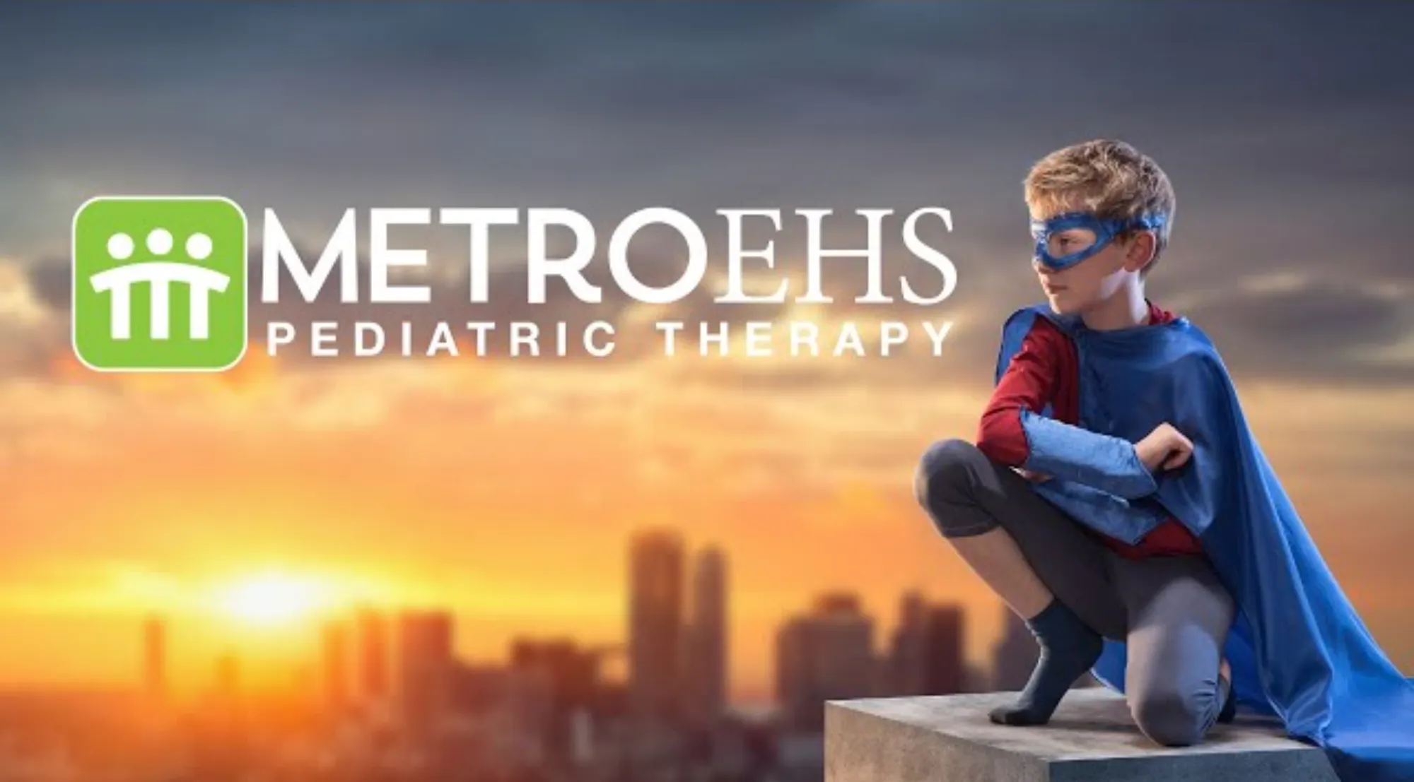 Young boy dressed as a superhero in a blue cape and mask crouches on a rooftop ledge at sunset, with MetroEHS Pediatric Therapy logo nearby.