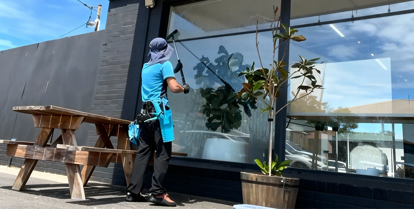 A person using a window cleaner to clean a large window, focused on removing dirt and streaks for a clear view.