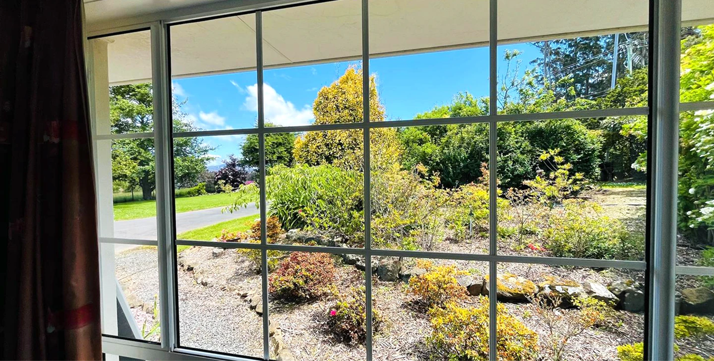 A person using a window cleaner to clean a large window, focused on removing dirt and streaks for a clear view.