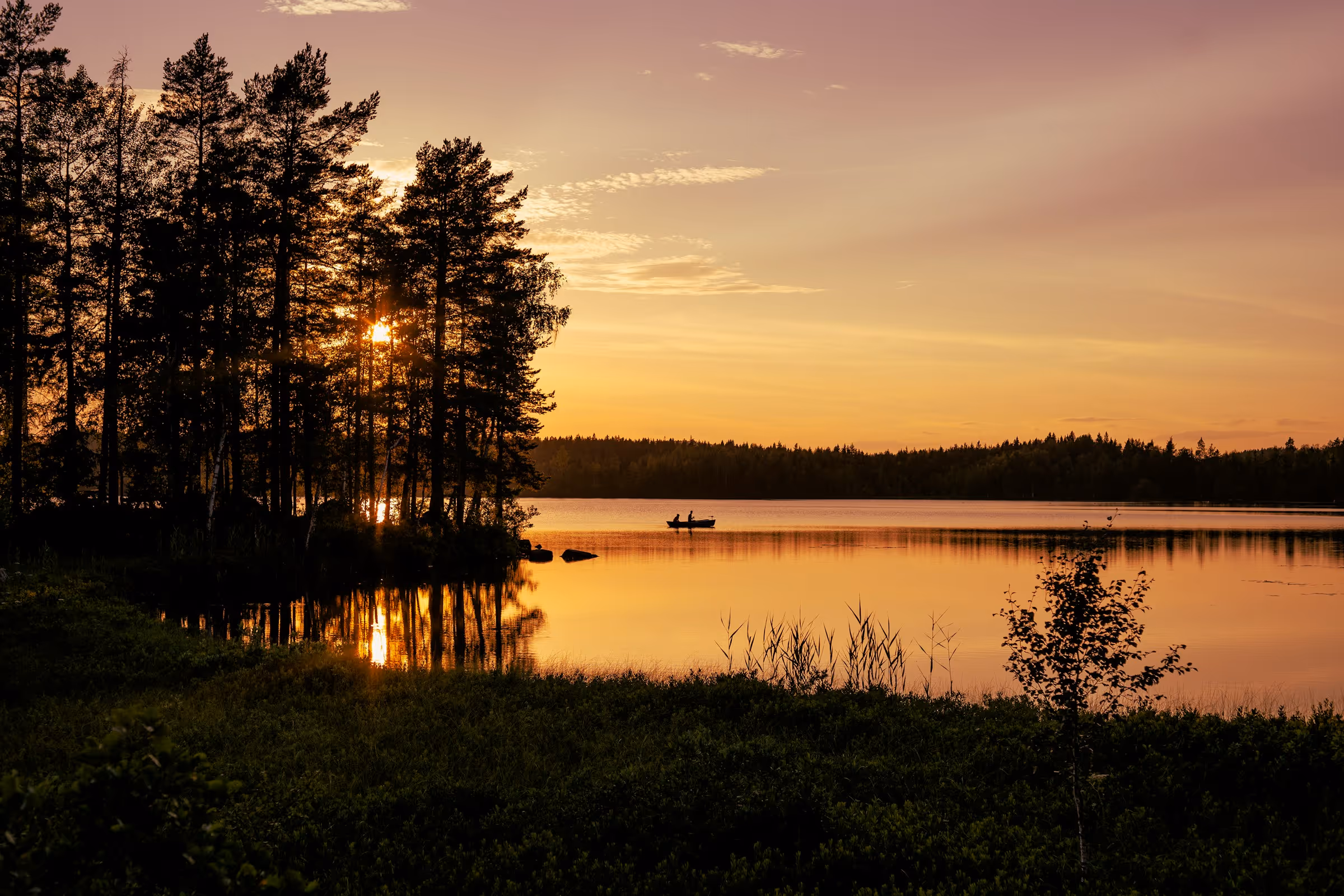 Solnedgång över sjö och skog på Orust