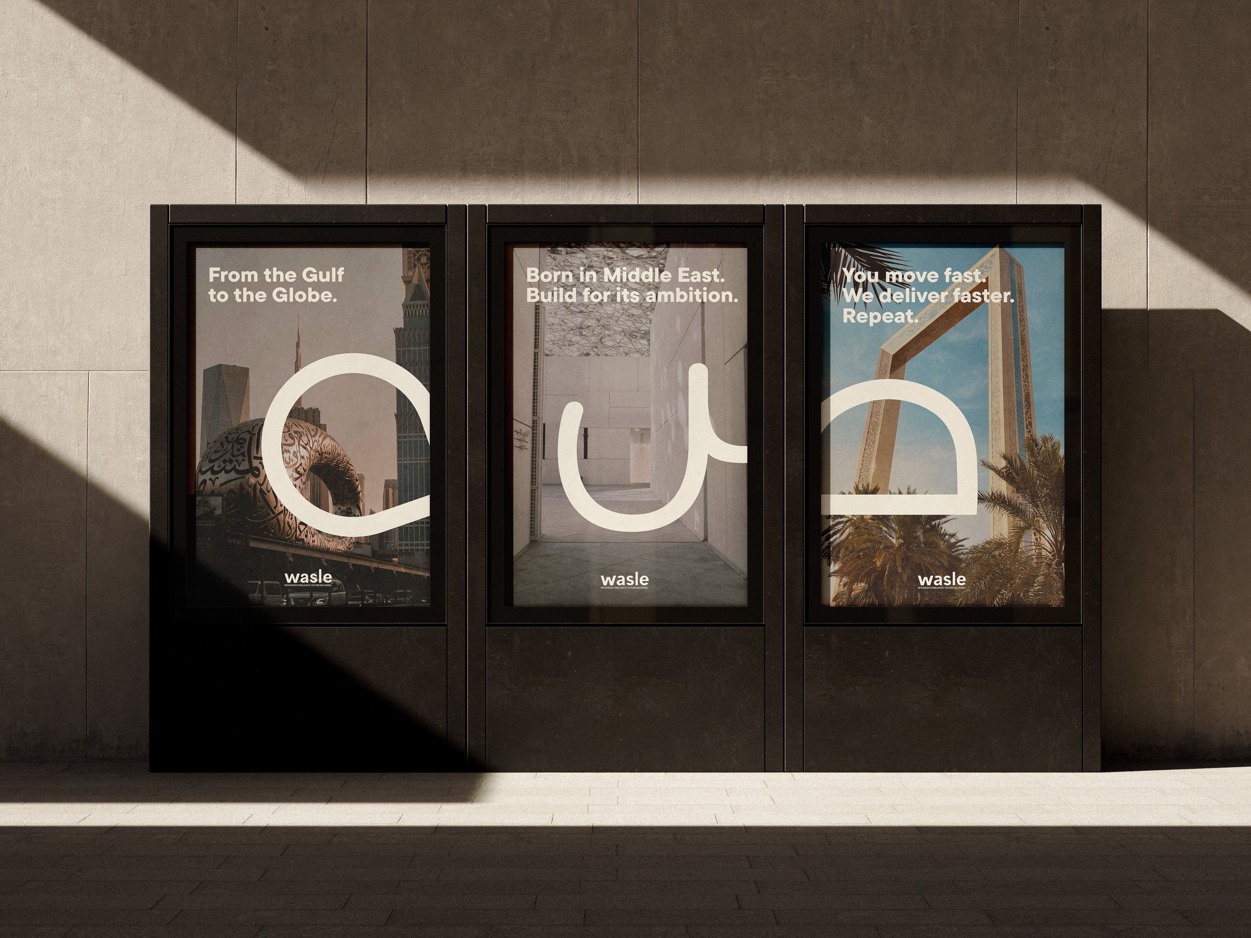 Three framed posters on a wall showing Middle Eastern architecture and the text: 'From the Gulf to the Globe.', 'Born in Middle East. Build for its ambition.', and 'You move fast. We deliver faster. Repeat.' with the brand name wasle.