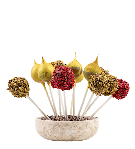 Kolorowe lizaki dekorowane posypką i złotym efektem w ceramicznej misce na białym tle.