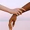 A close-up image of two hands gently reaching for each other, one with lighter skin and the other with darker skin, against a soft, blurred background.