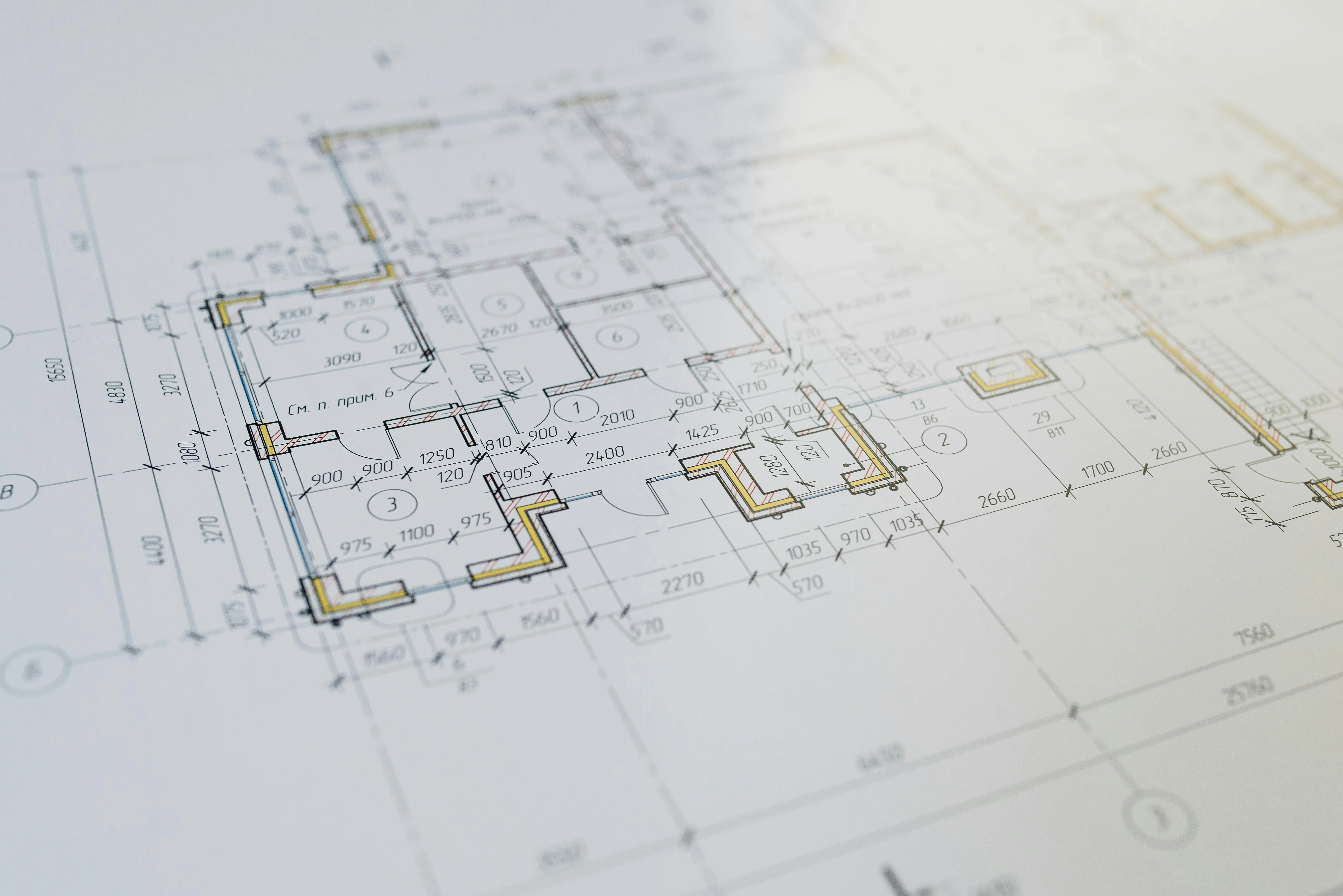 Technische Baupläne mit Maßen und Raumaufteilungen auf weißem Papier.