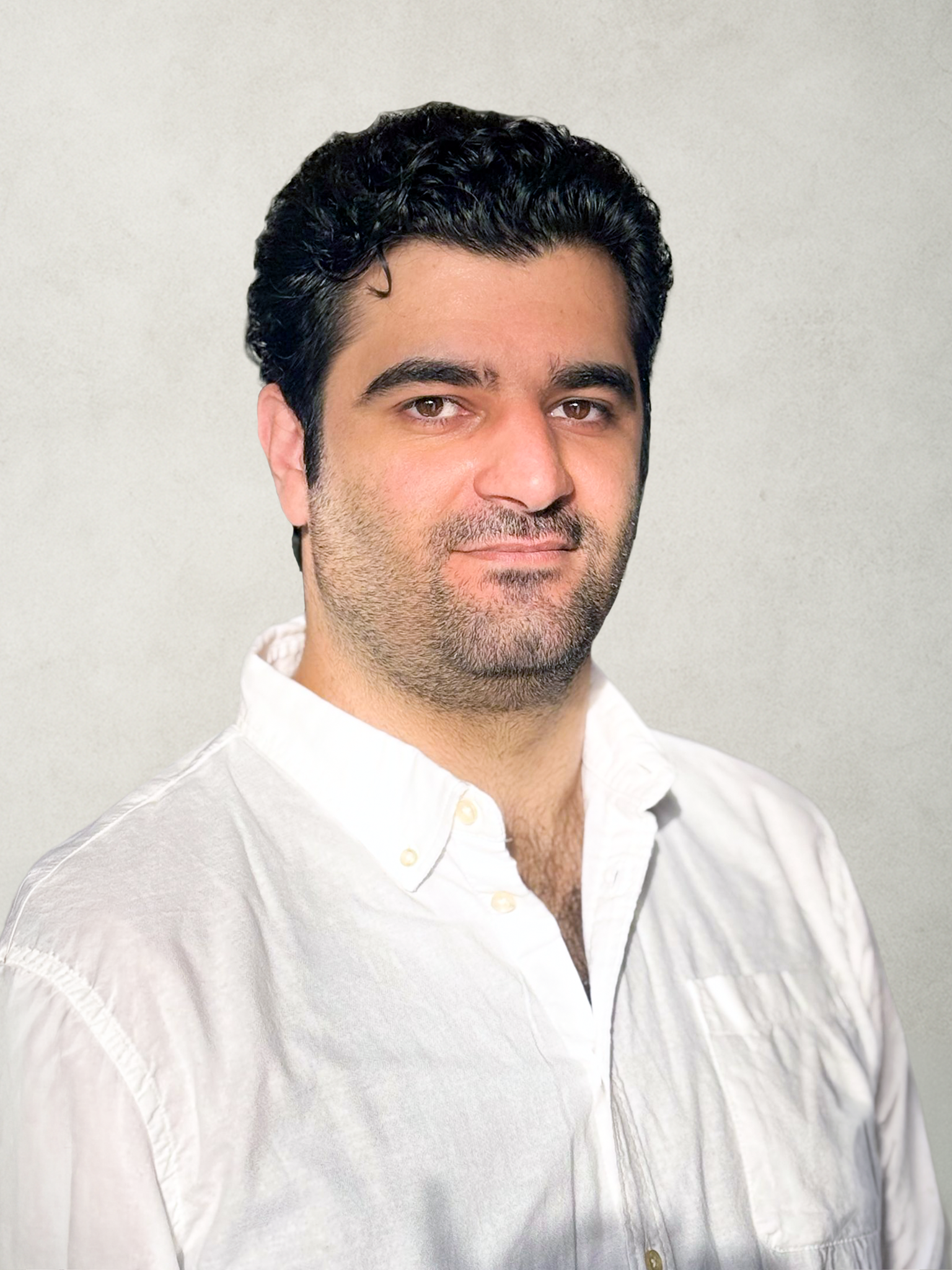 Smiling man with dark hair wearing a black leather jacket and black shirt against a black background.