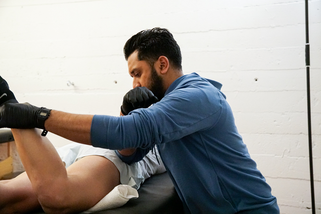 Athlete working with a provider on therapeutic exercise at a sports physical therapy clinic in Oakland, CA