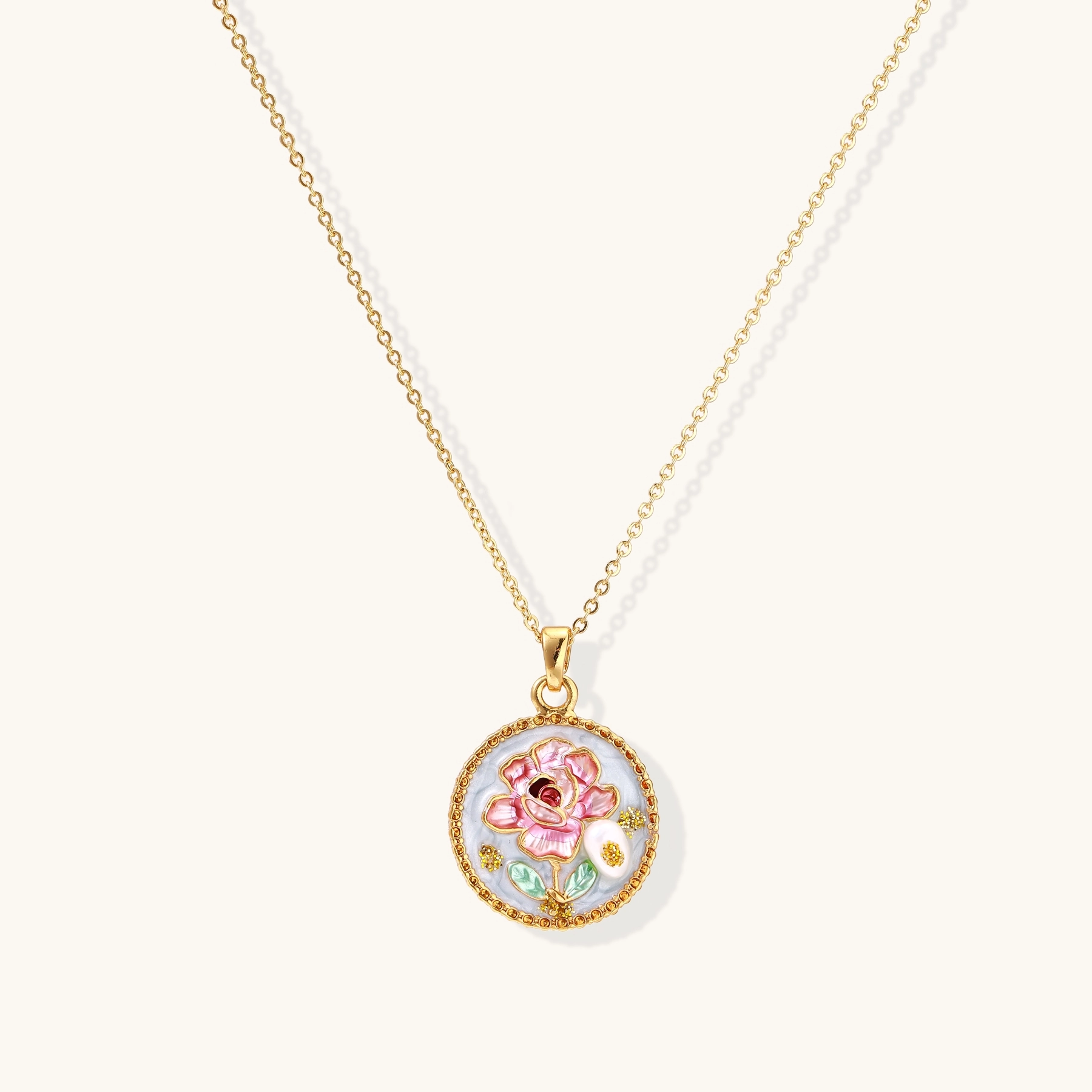 Gold-plated circular pendant with pink enamel rose, pearl background, and delicate beaded border on chain