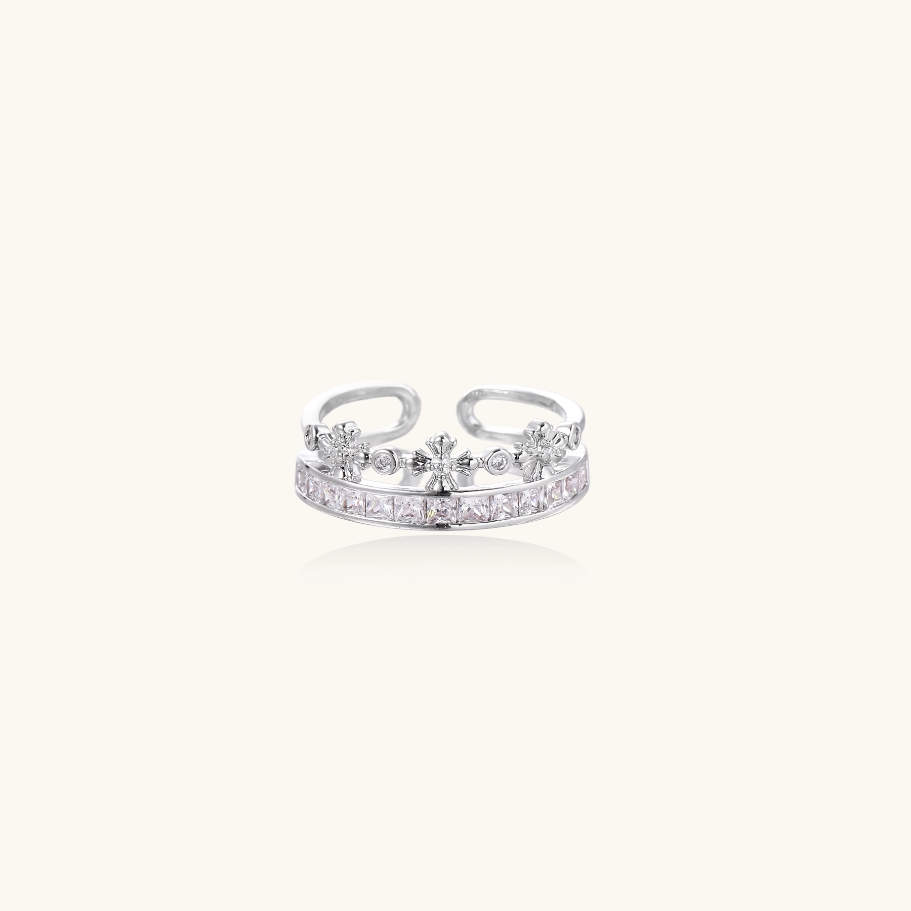 Silver-toned adjustable crown ring with channel-set square zirconia stones and delicate floral details on white background