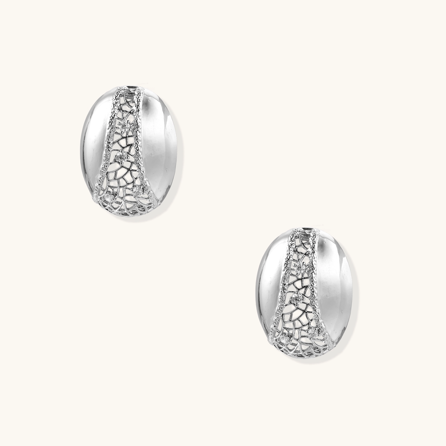 White gold-plated dome hoop earrings with geometric lattice pattern and zirconia stones on cream background