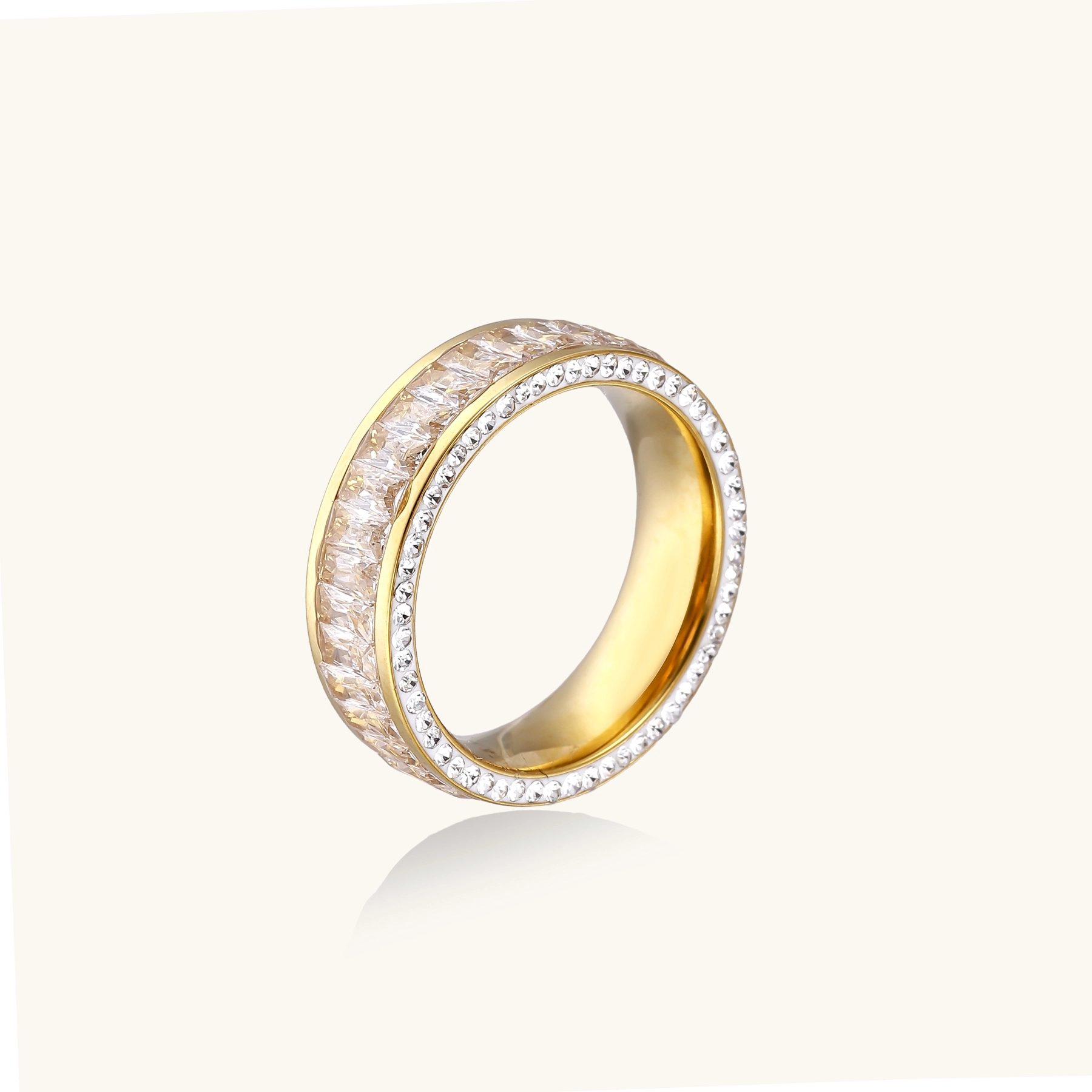 14K gold-plated ring with dual rows of clear baguette and round zirconia stones on cream background.