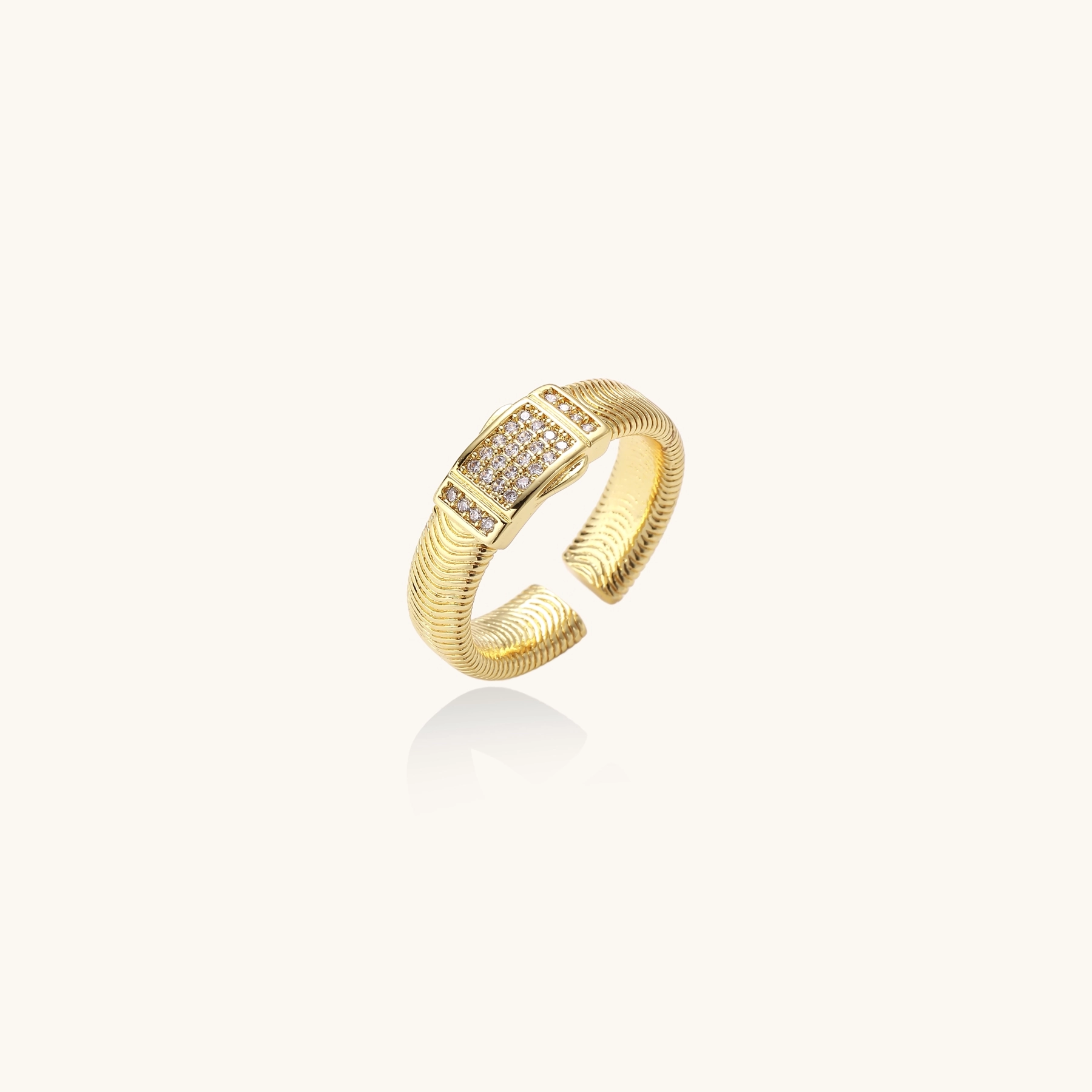 Gold-plated adjustable ring with ribbed band and rectangular pavé cubic zirconia panel on white background.