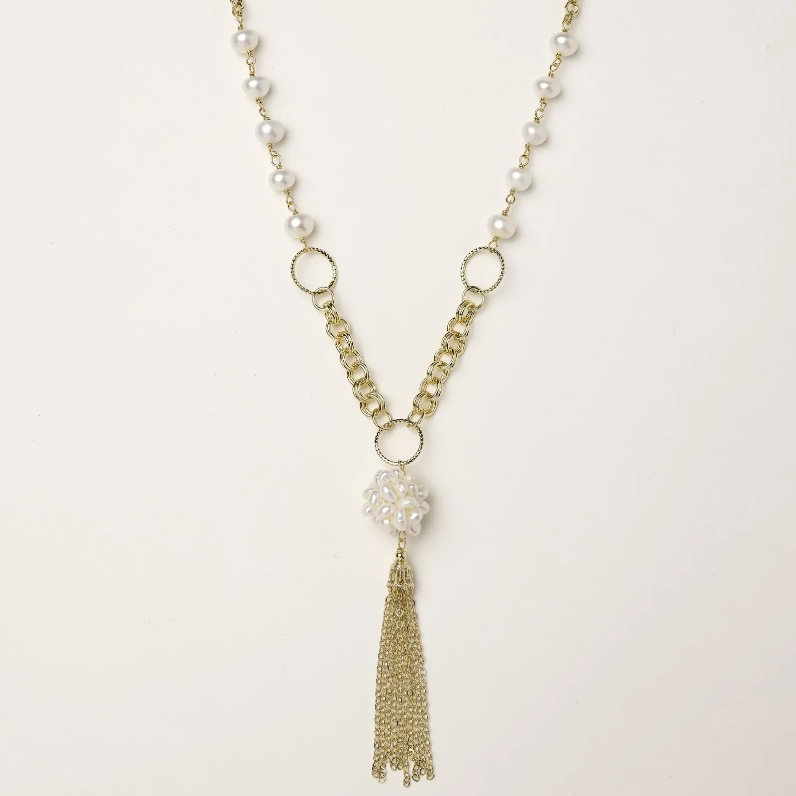 Long gold-plated necklace with freshwater pearls, chunky chain links, and flowing tassel pendant
