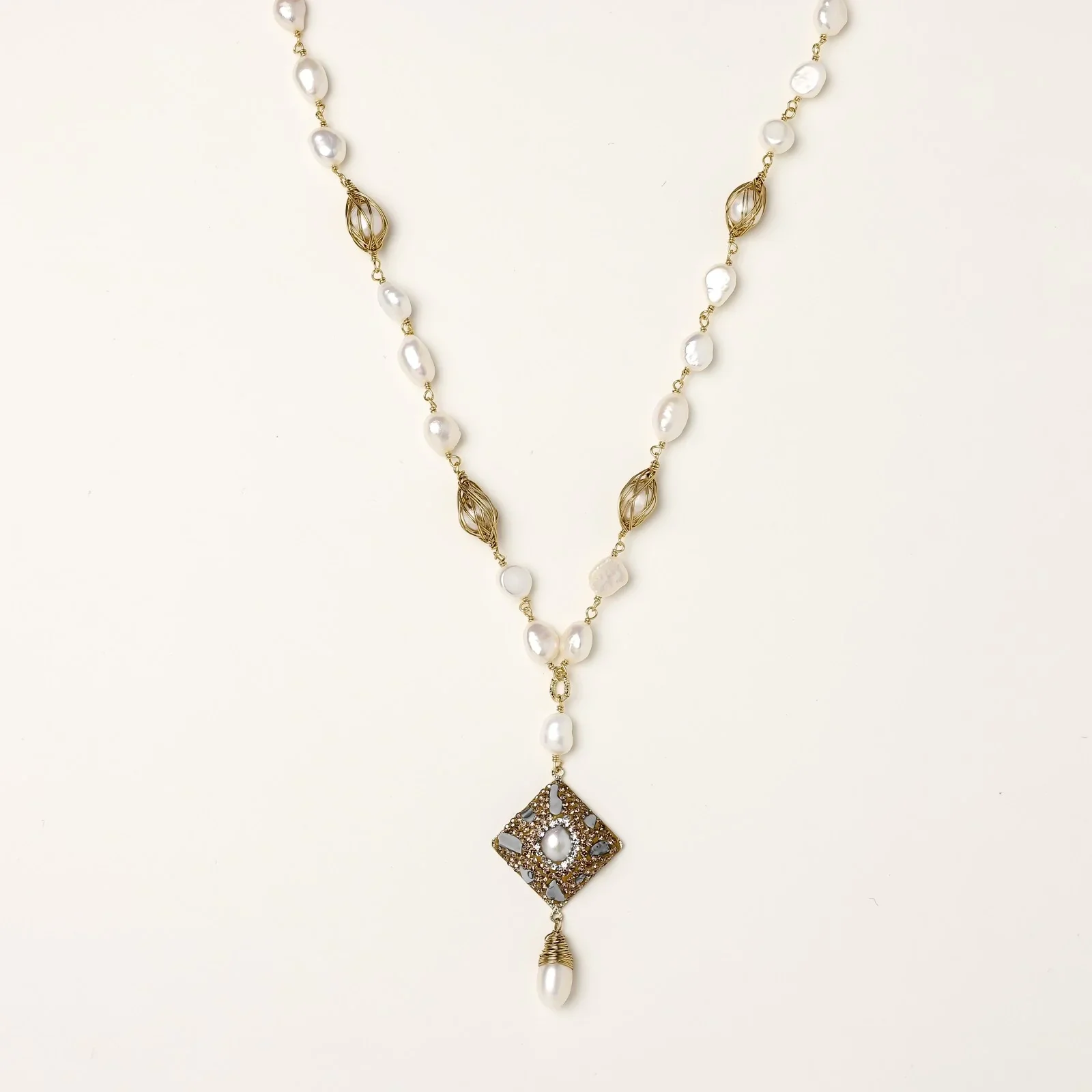 Y-shaped necklace with freshwater pearls, gold filigree stations, and ornate diamond-shaped centerpiece with pearl drop