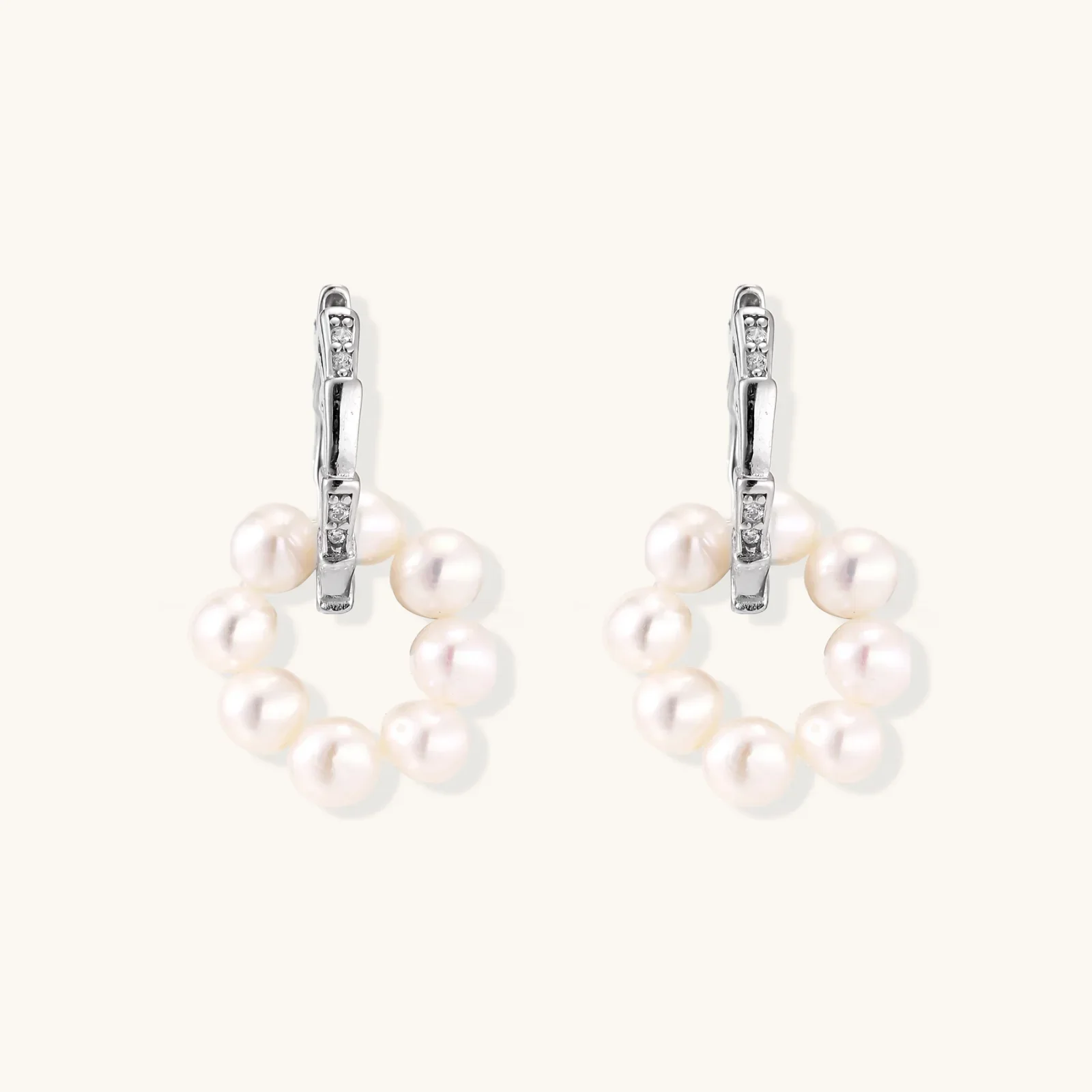 Rhodium-plated silver hoop earrings with freshwater pearls arranged in crescent formation and diamond accents