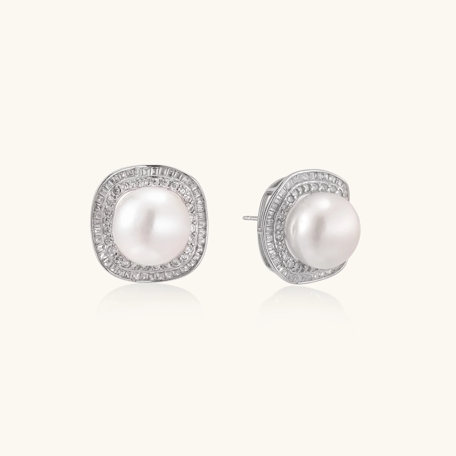 Cushion-shaped sterling silver stud earrings with freshwater pearls surrounded by geometric diamond halos